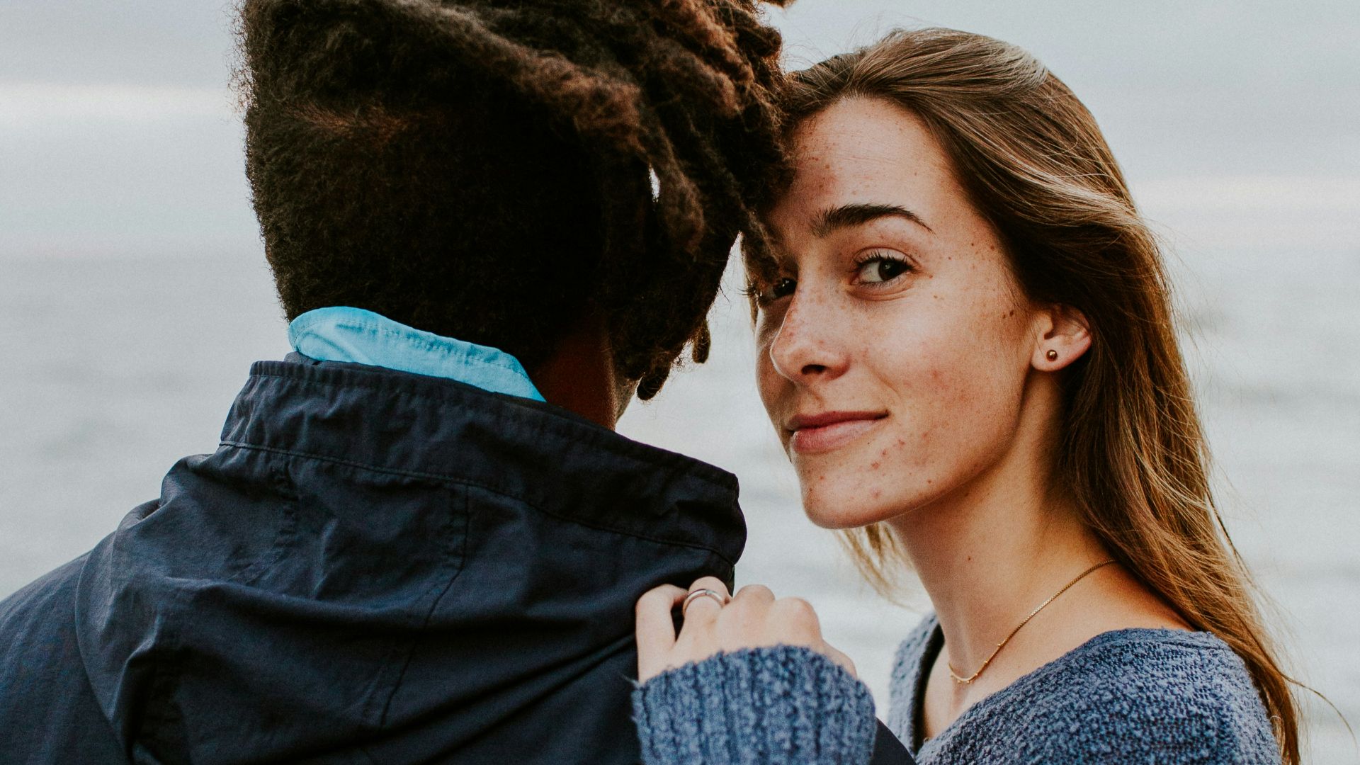 woman in blue long sleeve shirt beside woman in gray long sleeve shirt