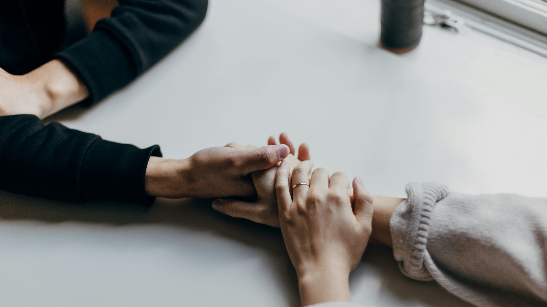 person in black long sleeve shirt holding babys feet