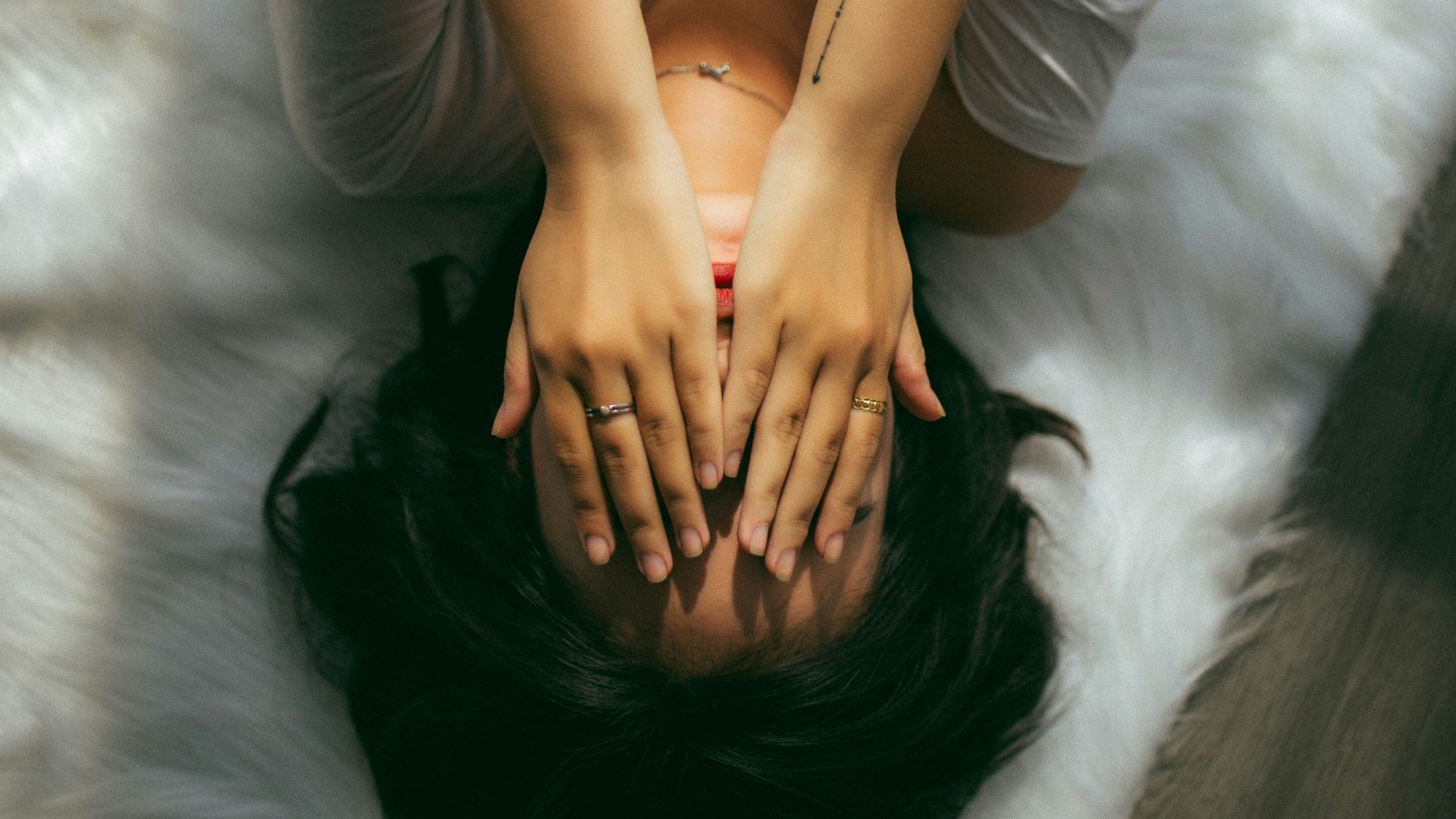 a woman holds her hands over her face