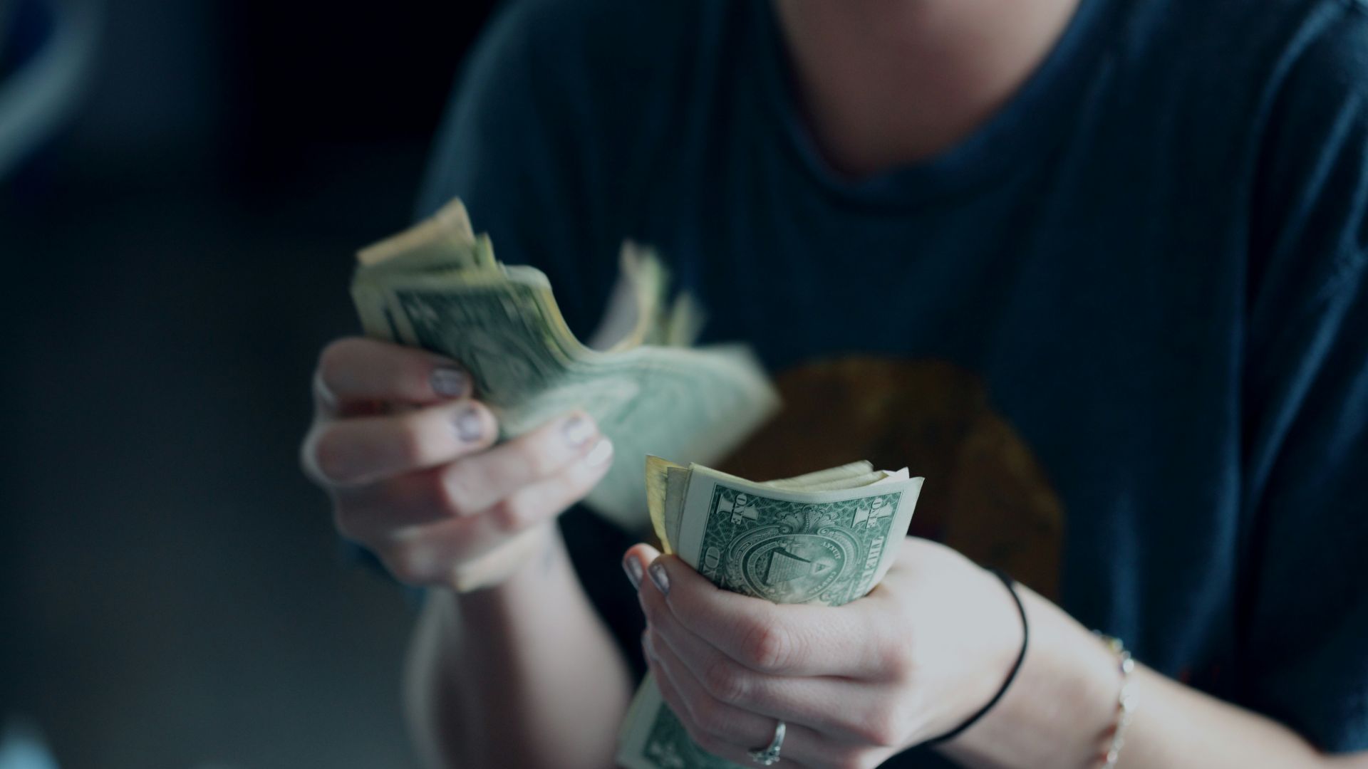 focus photography of person counting dollar banknotes