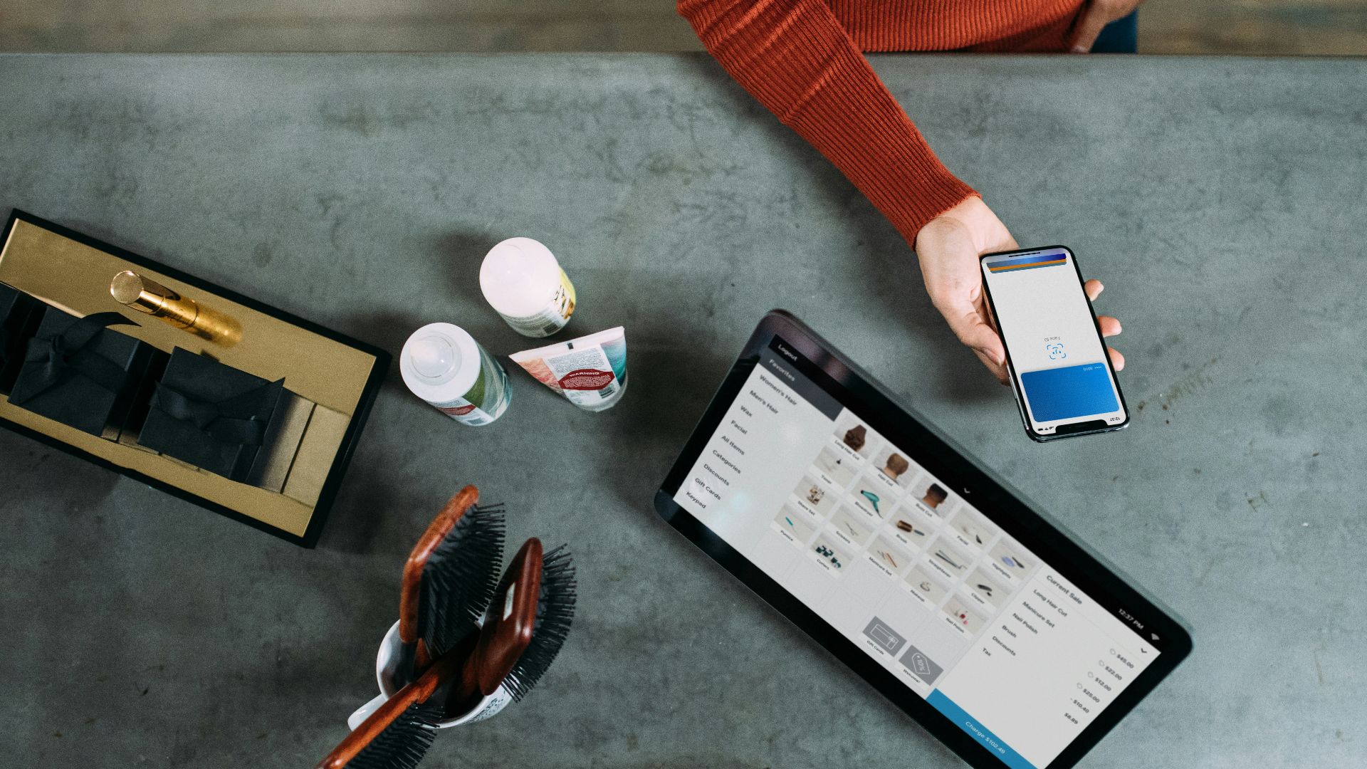 person holding smartphone beside tablet computer