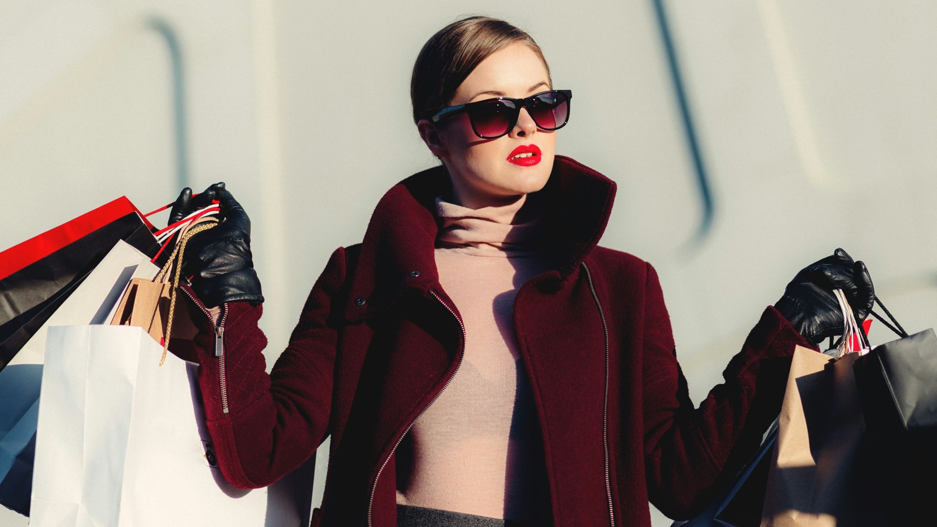 photo of woman holding white and black paper bags
