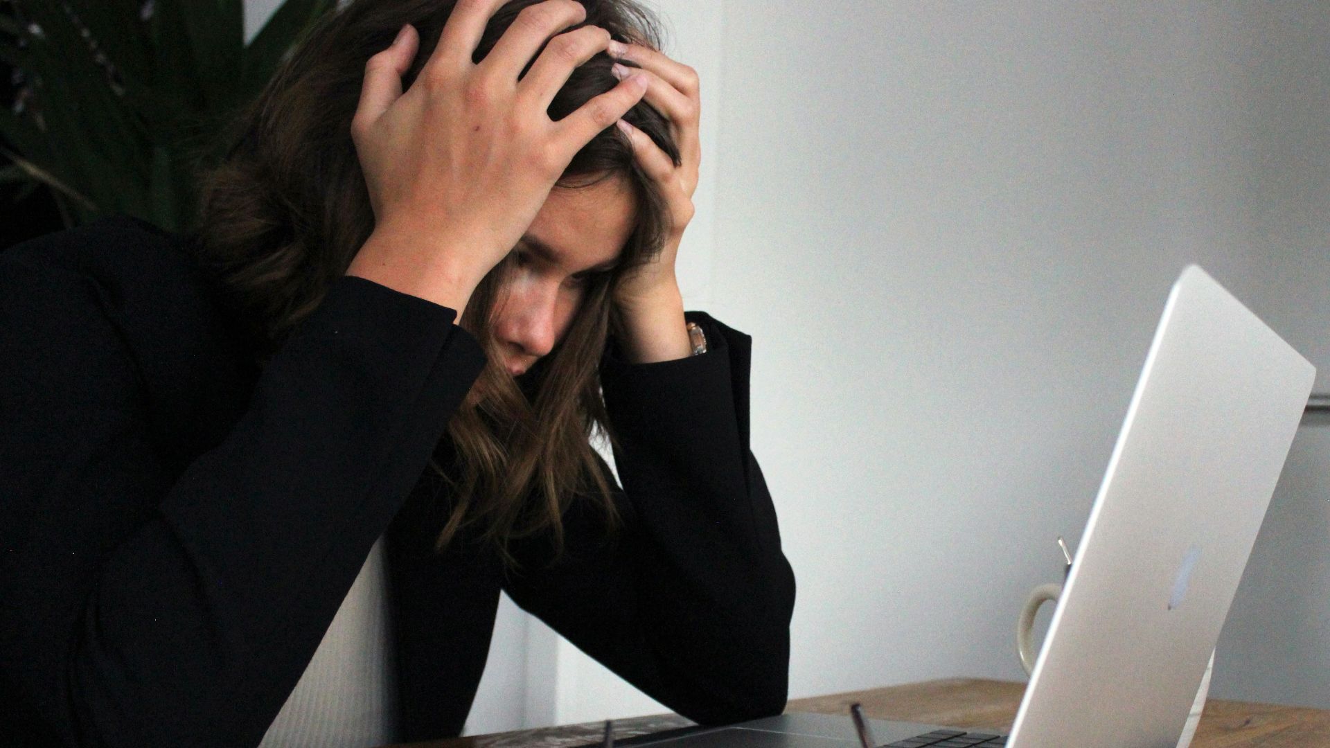 a woman sitting in front of a laptop computer