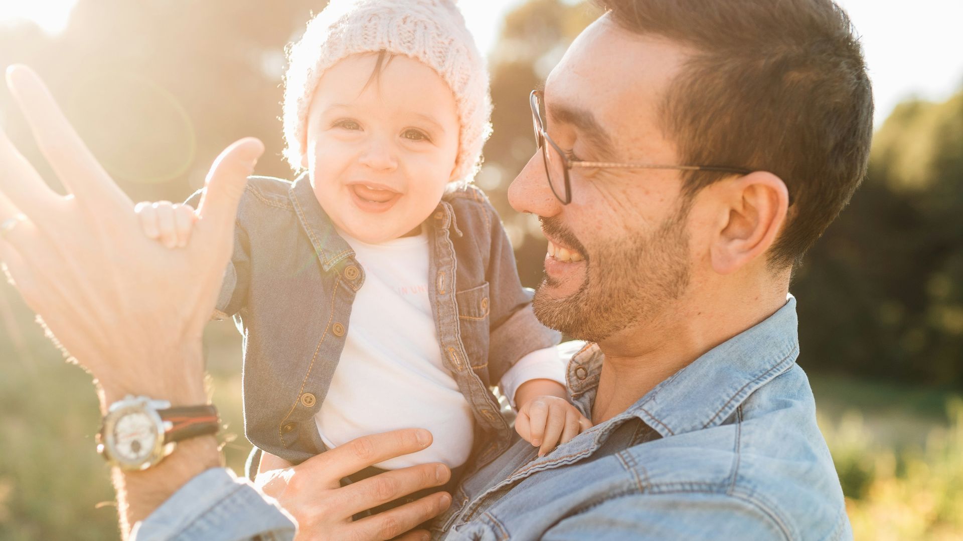 man in blue denim jacket carrying girl in white sweater during daytime