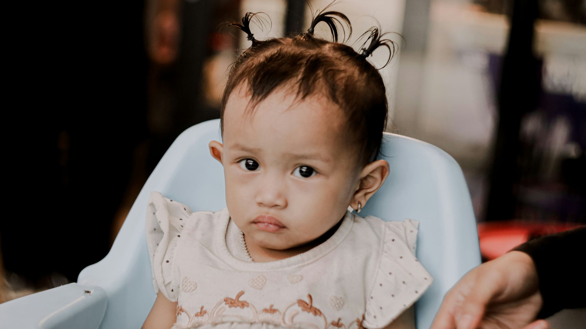 A baby sitting in a blue high chair