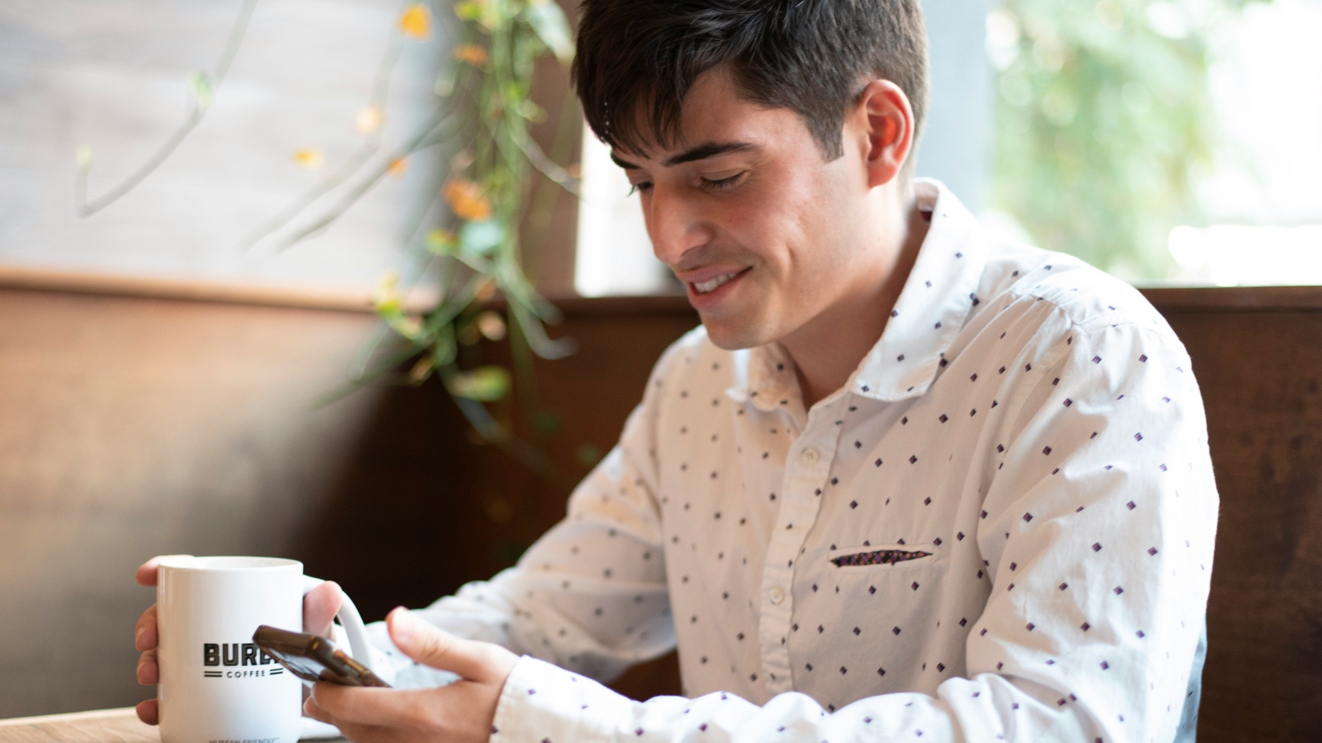 a man sitting at a table looking at his cell phone