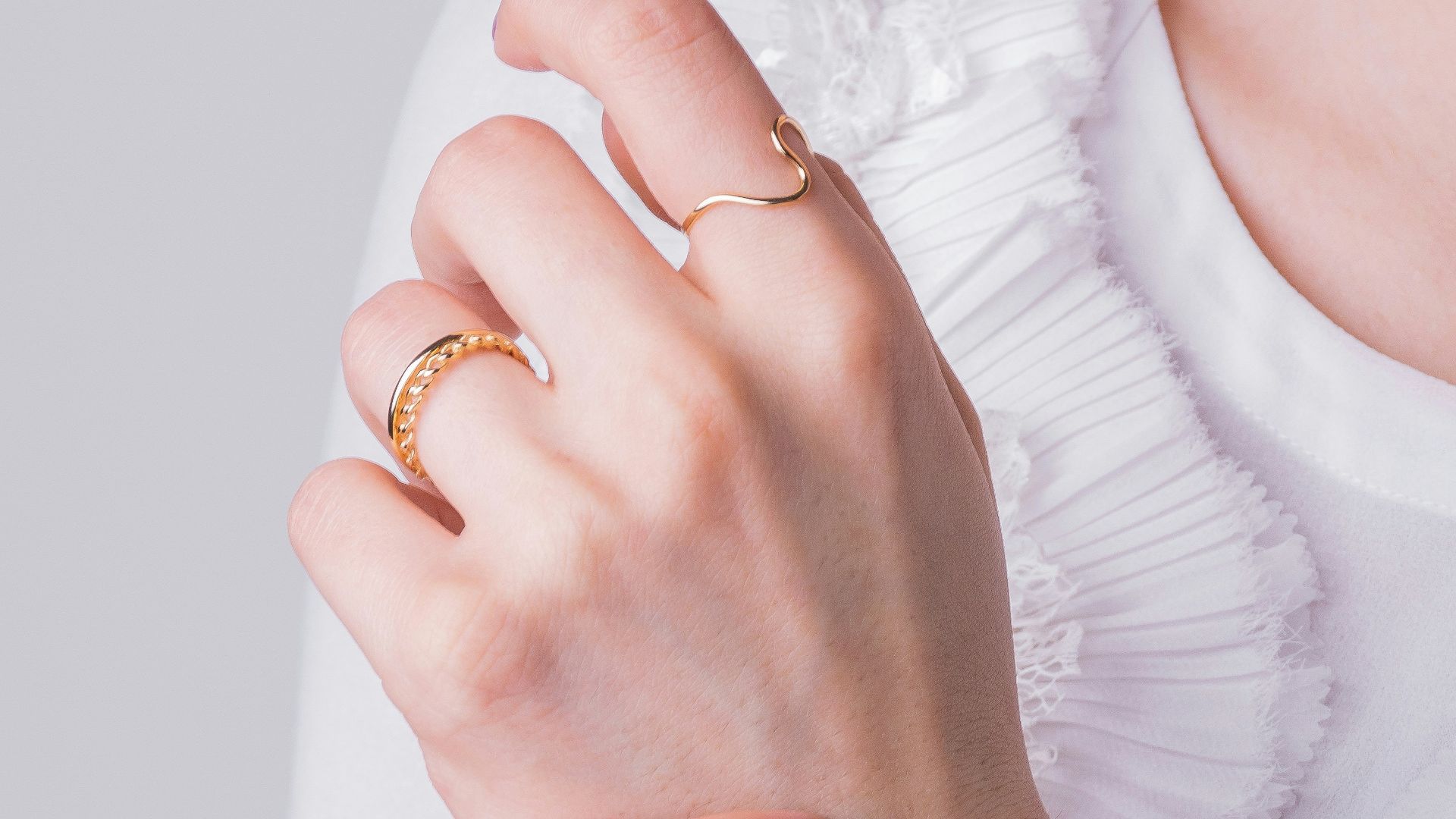 a woman in a white shirt is holding her hands together