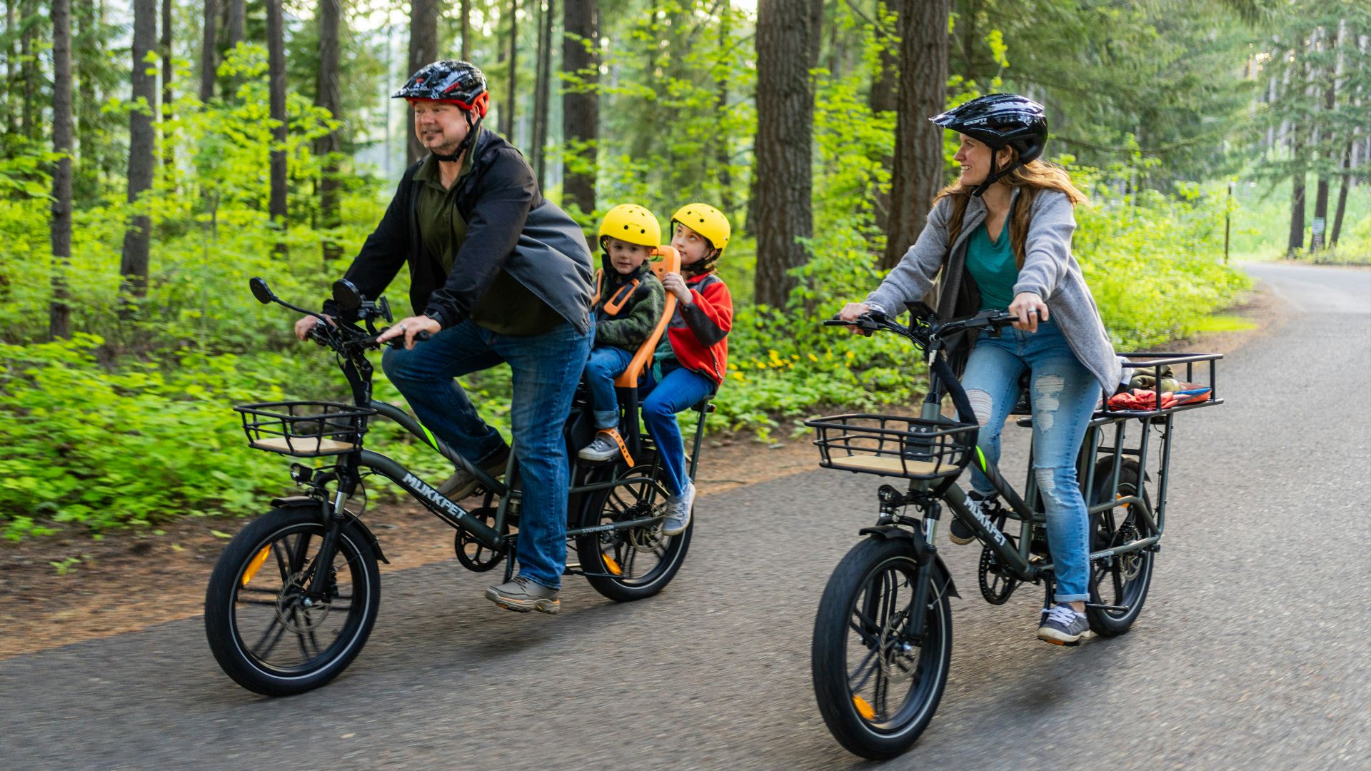 a family of three riding bikes down a road