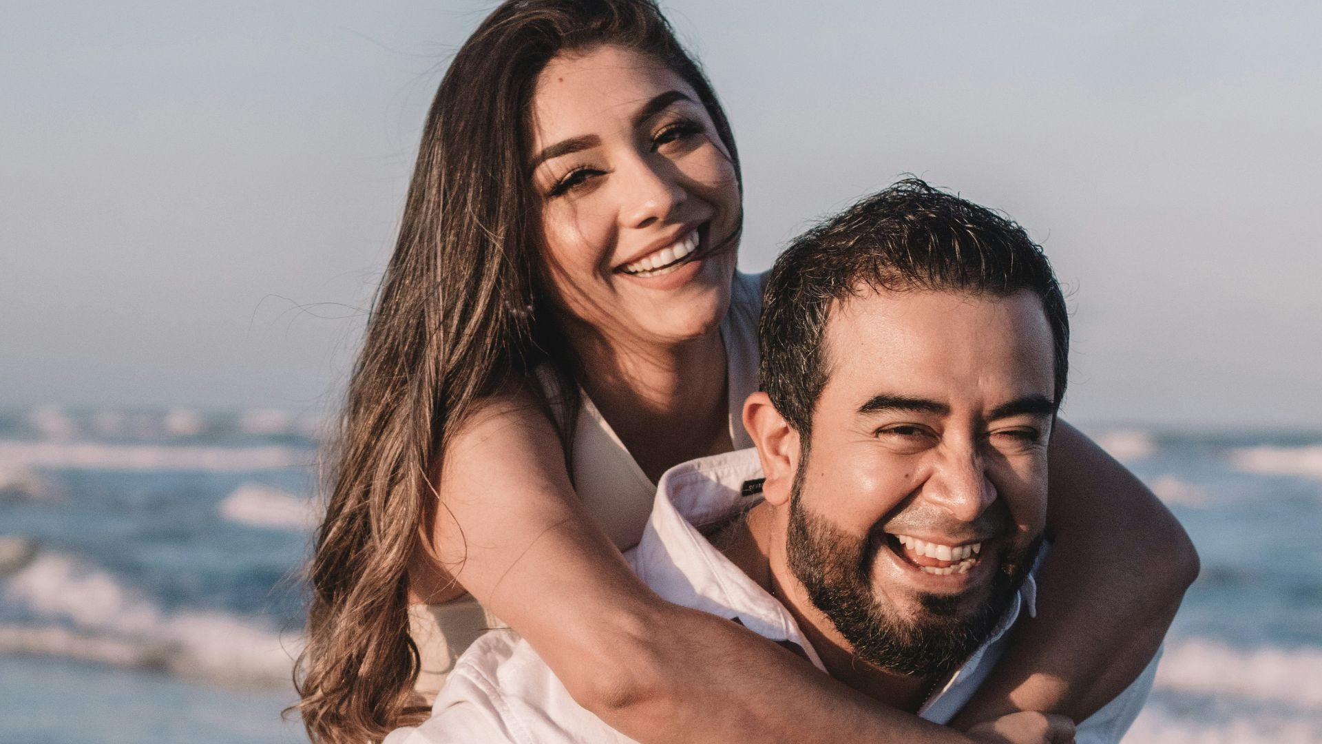 man in white dress shirt hugging woman in white dress