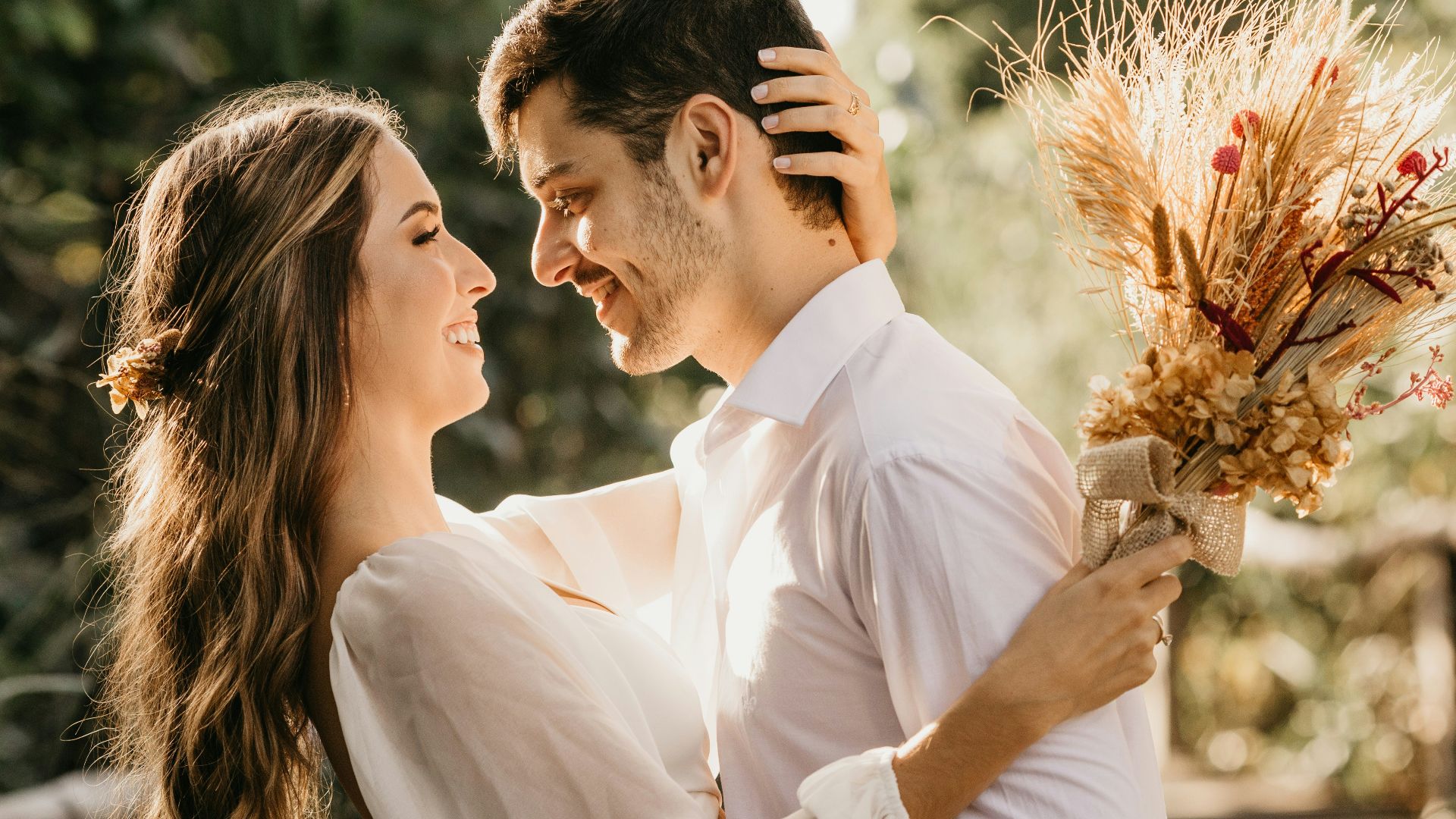 man in white dress shirt holding brown flower bouquet