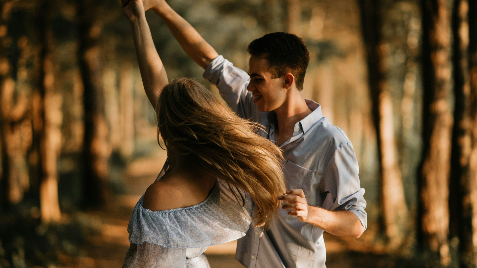 man and woman dancing at center of trees