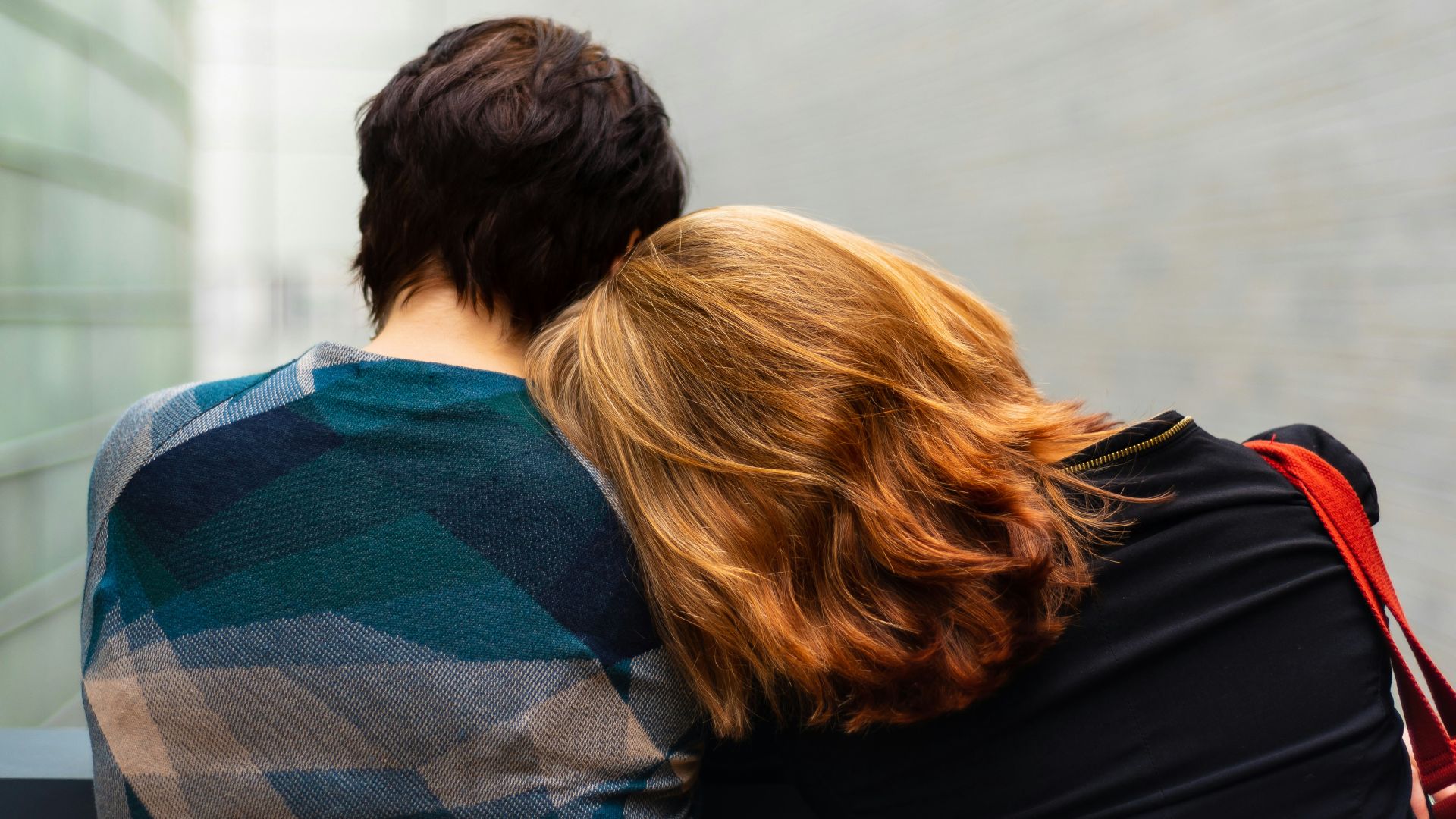a woman rests her head on another person's shoulder