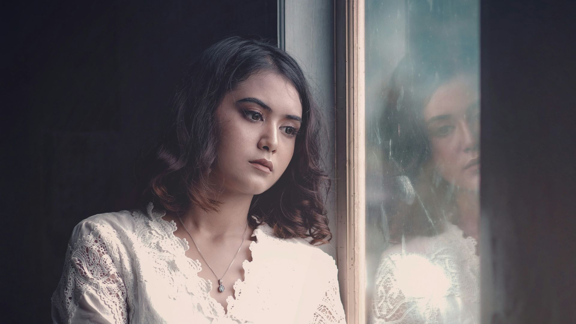 a woman is looking out of a window