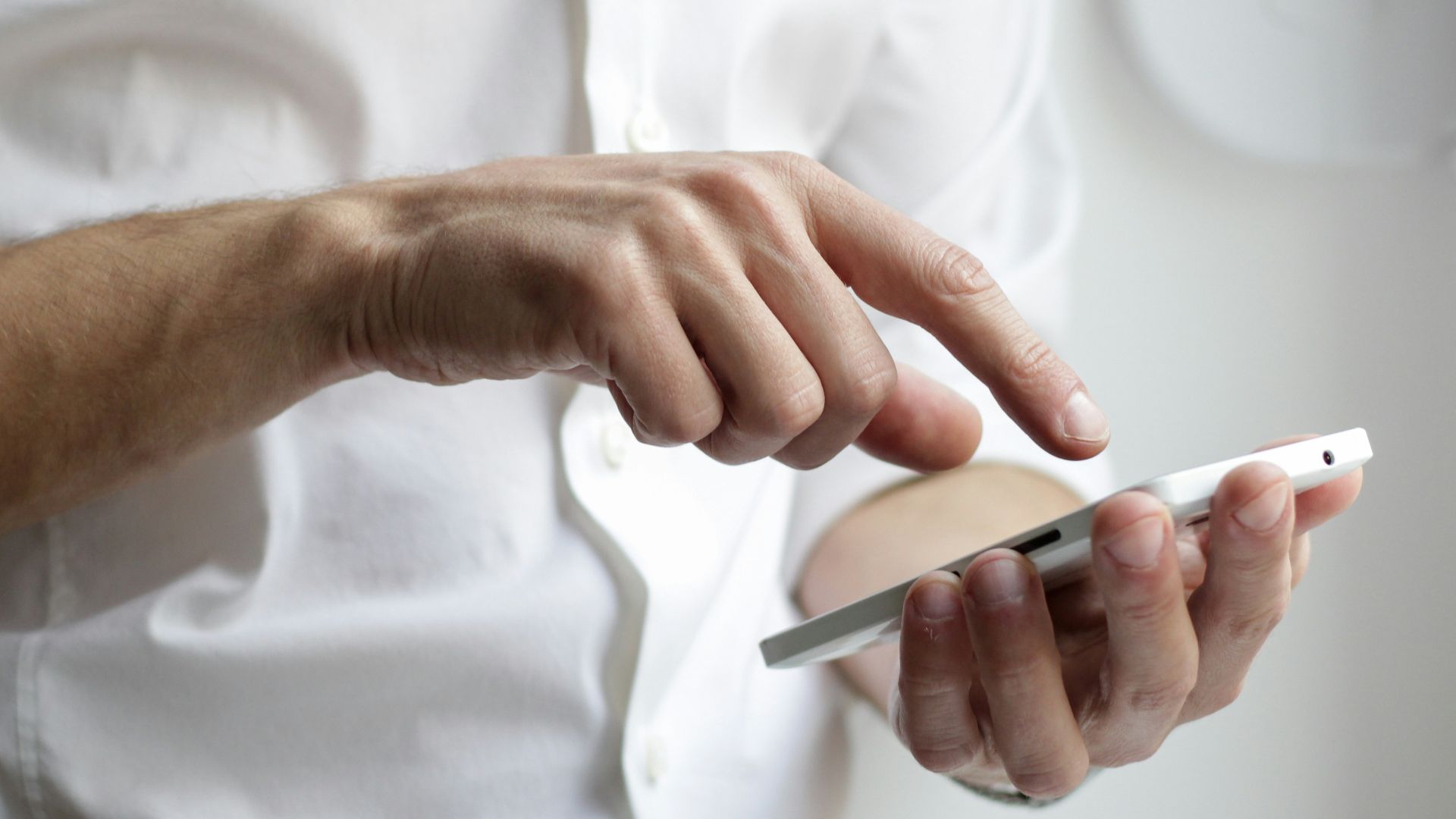 person holding white Android smartphone in white shirt