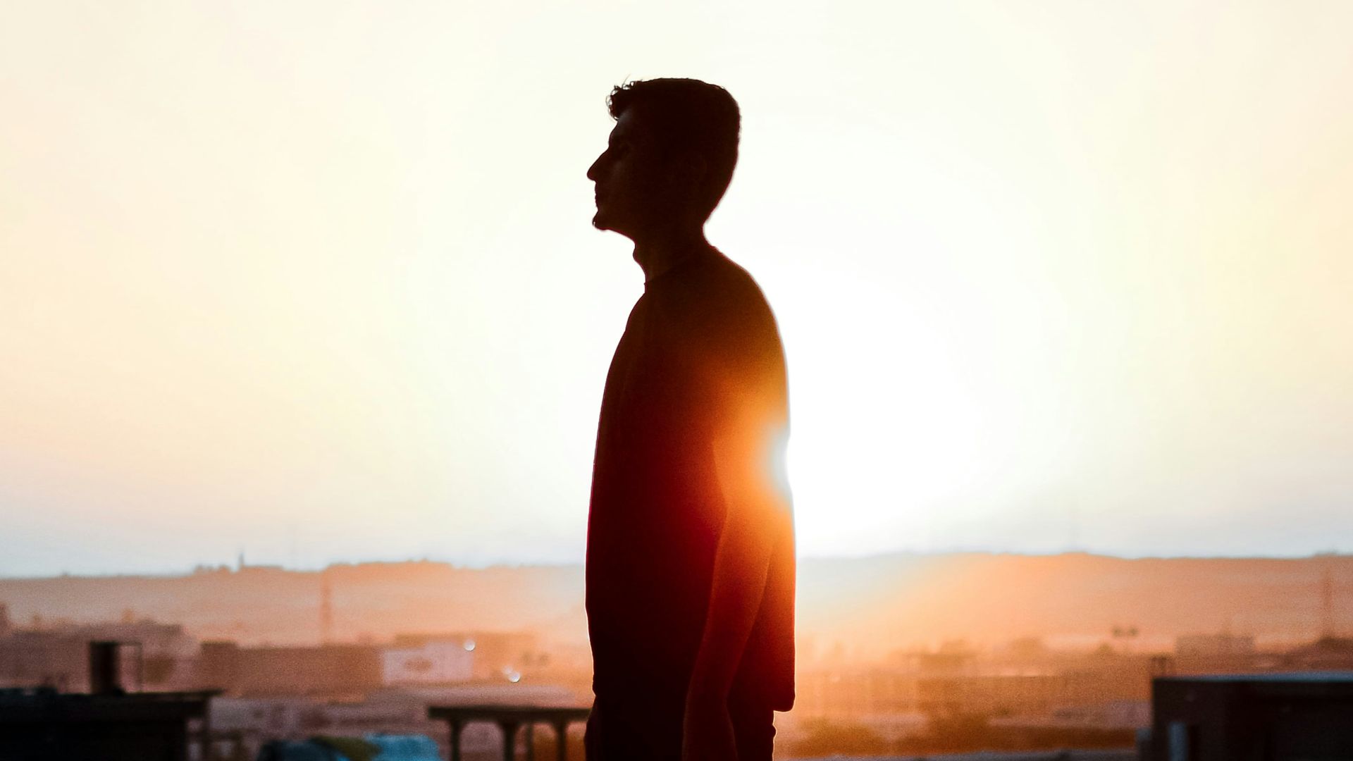 a man standing on top of a roof next to a building