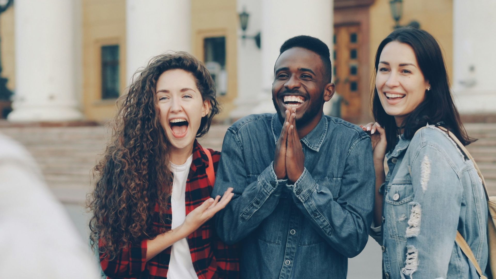 People happily pose for a photograph outside.