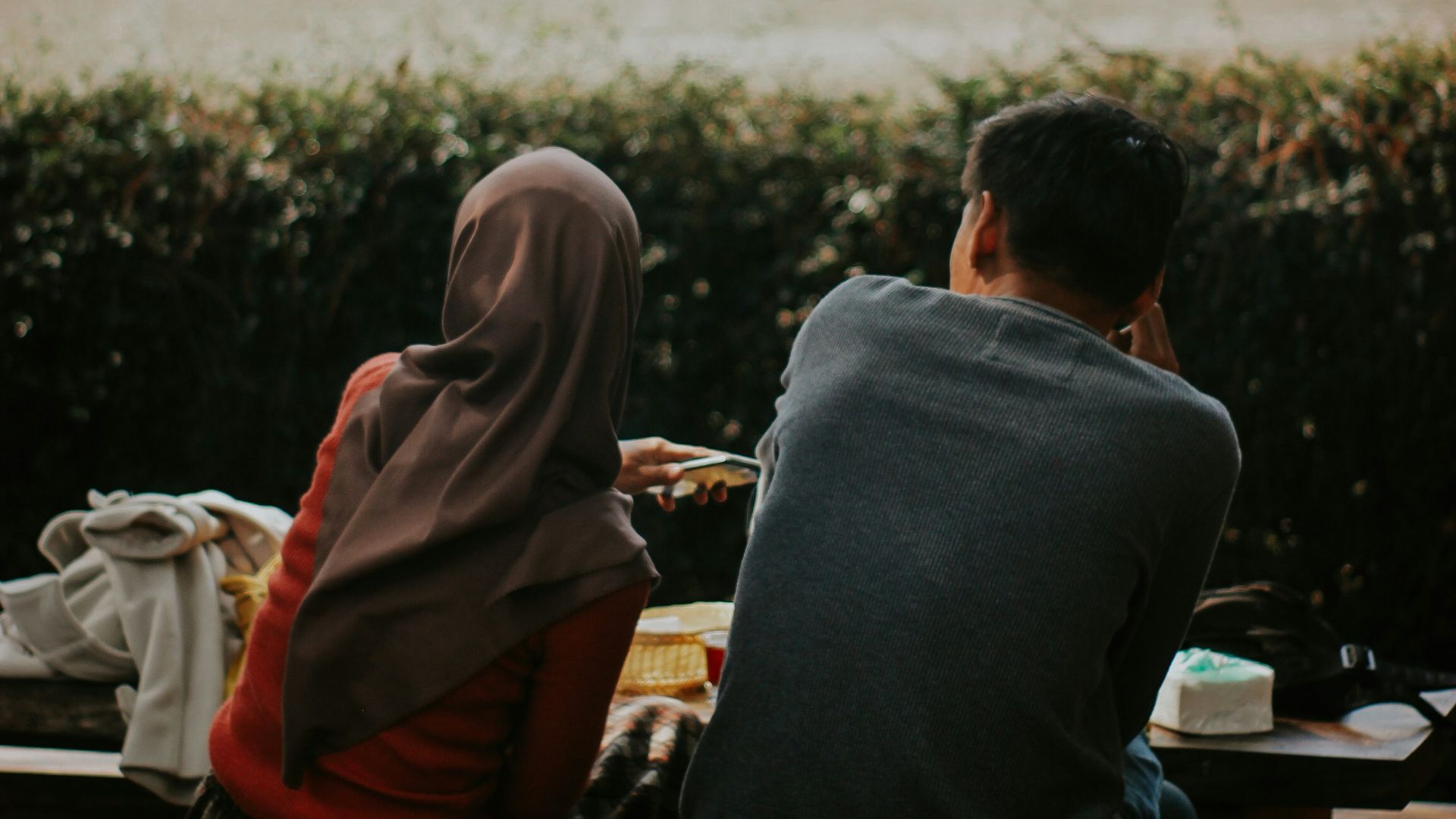 man and woman sitting on bench during daytime