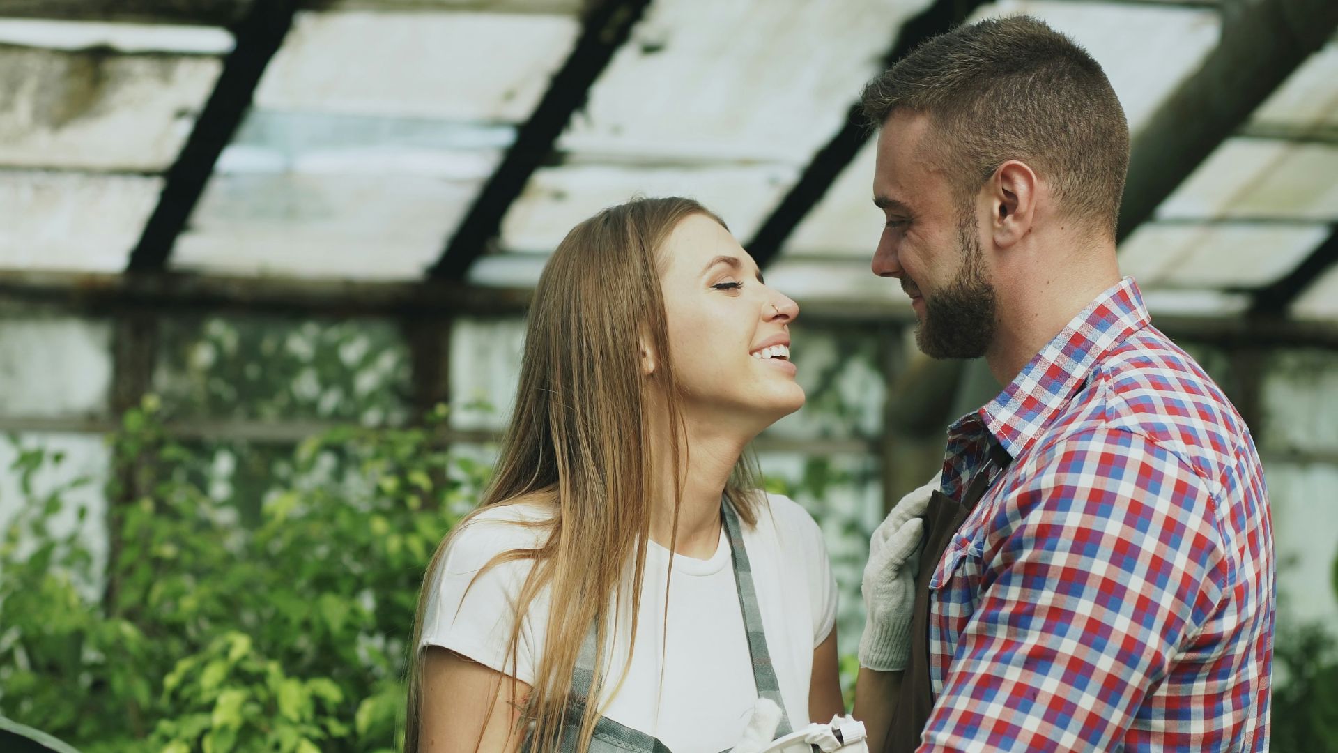 Couple embracing in a greenhouse with plants