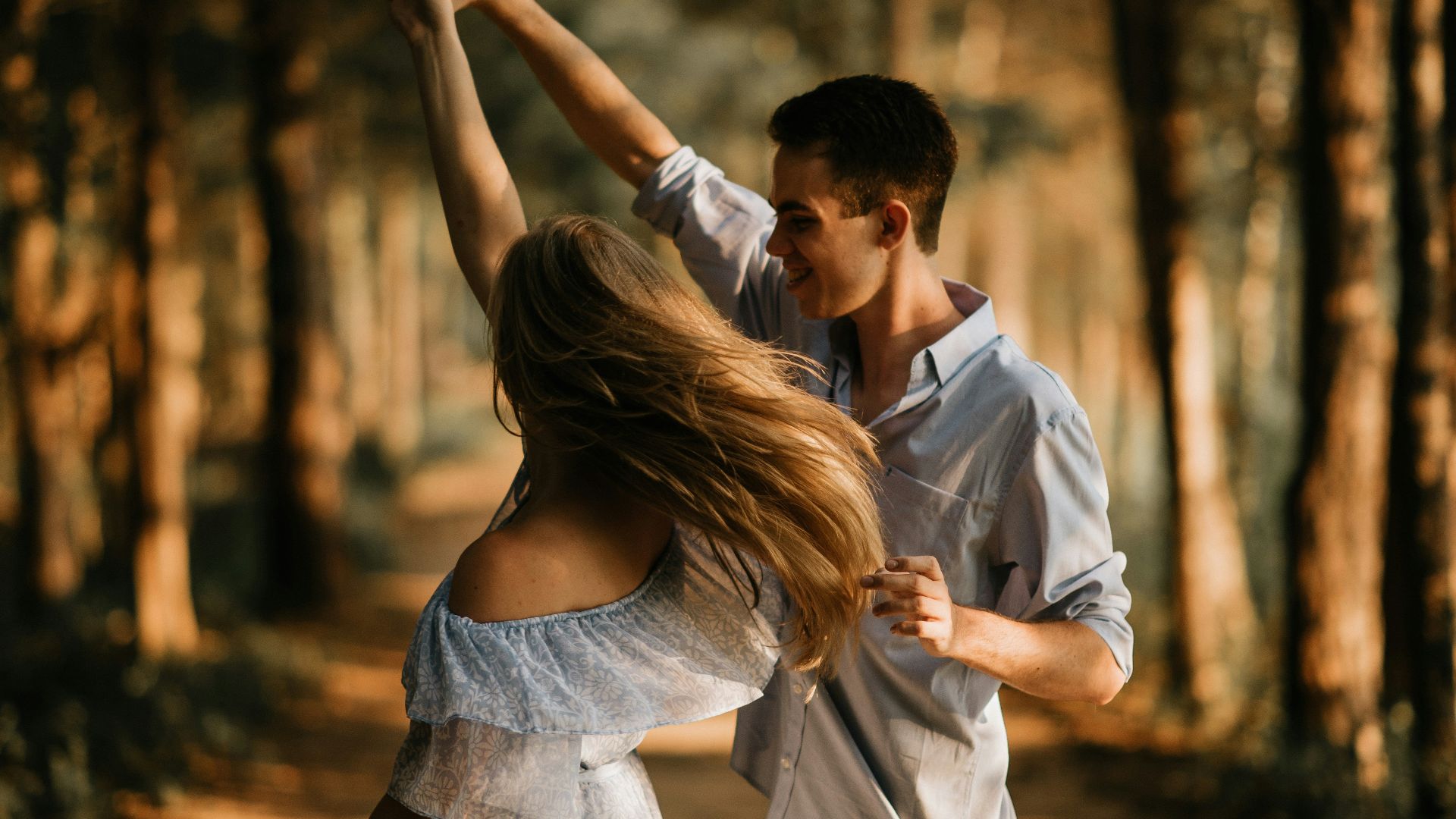 man and woman dancing at center of trees