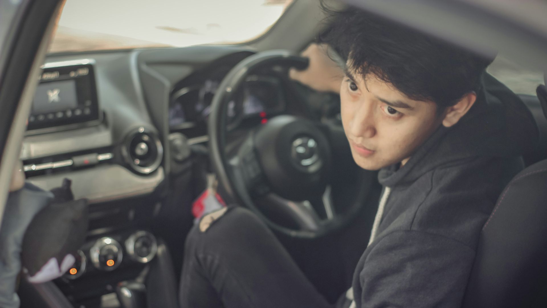 woman in black hoodie sitting on drivers seat