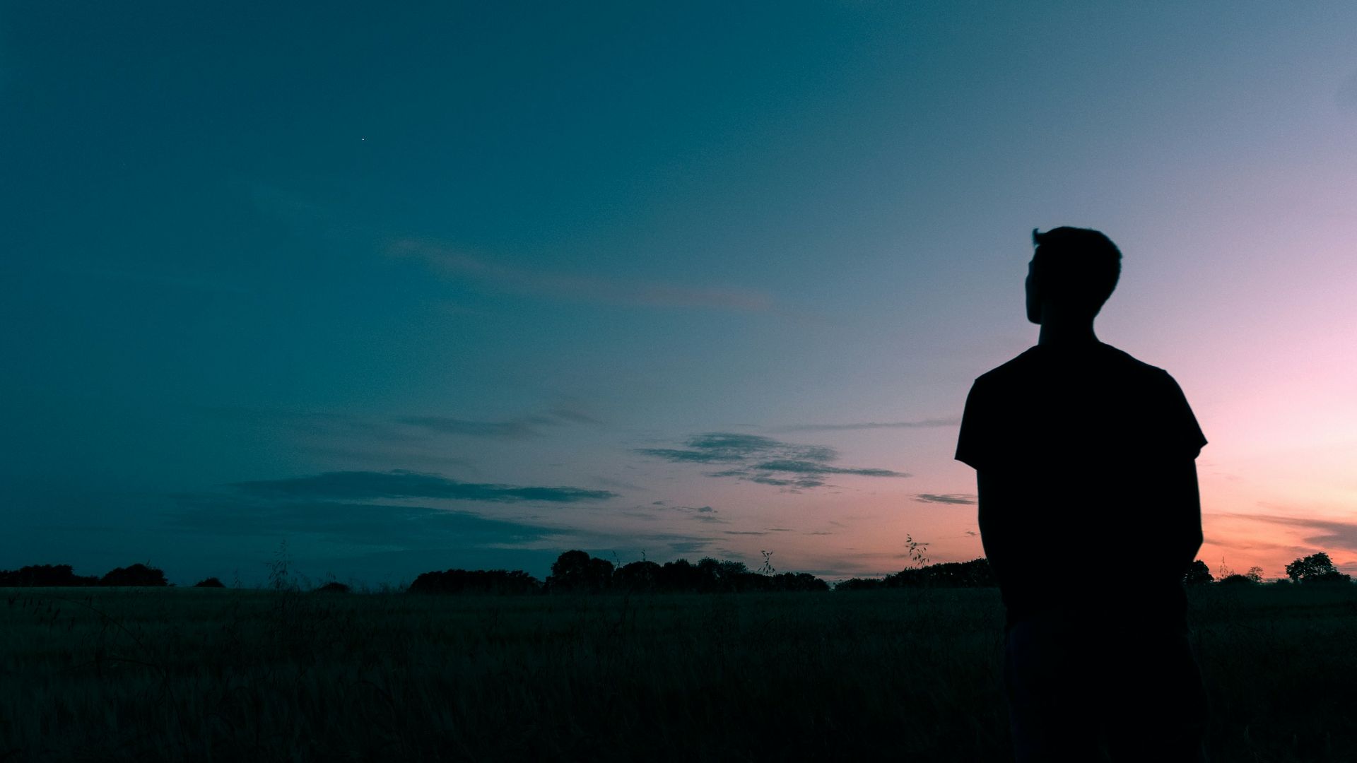 silhouette of man looking star during sunset