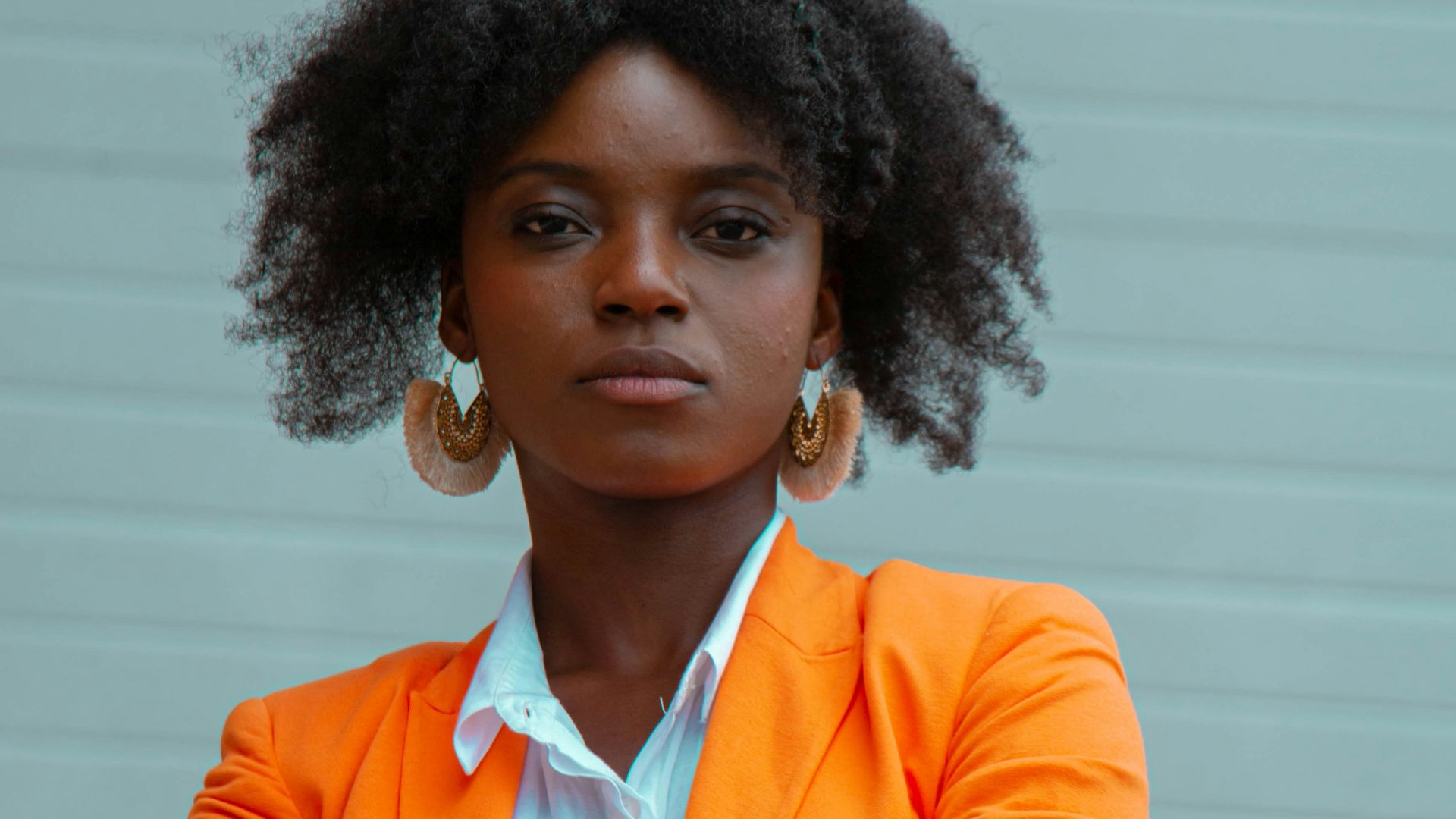 woman in orange blazer standing