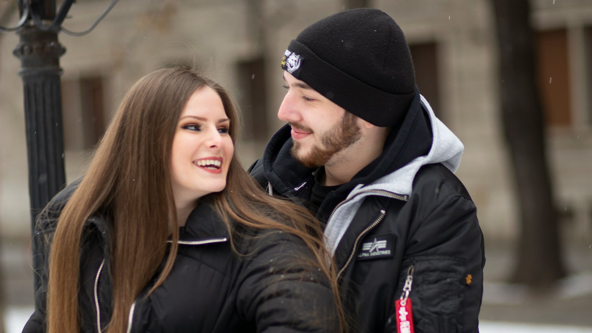 a man and a woman standing next to a street light