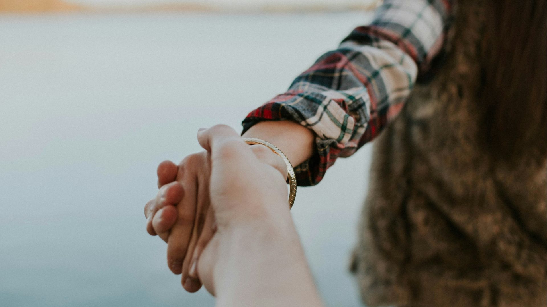 shallow focus photography of man and woman holding hands