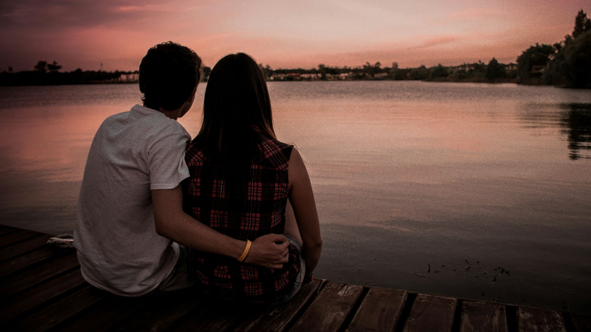 man and woman sitting on dock