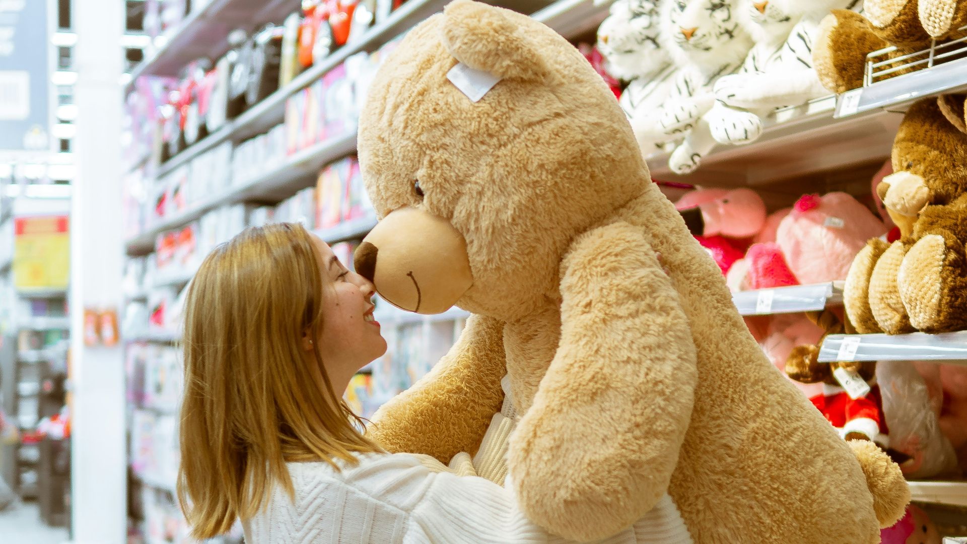 woman carrying life size bear plush toy