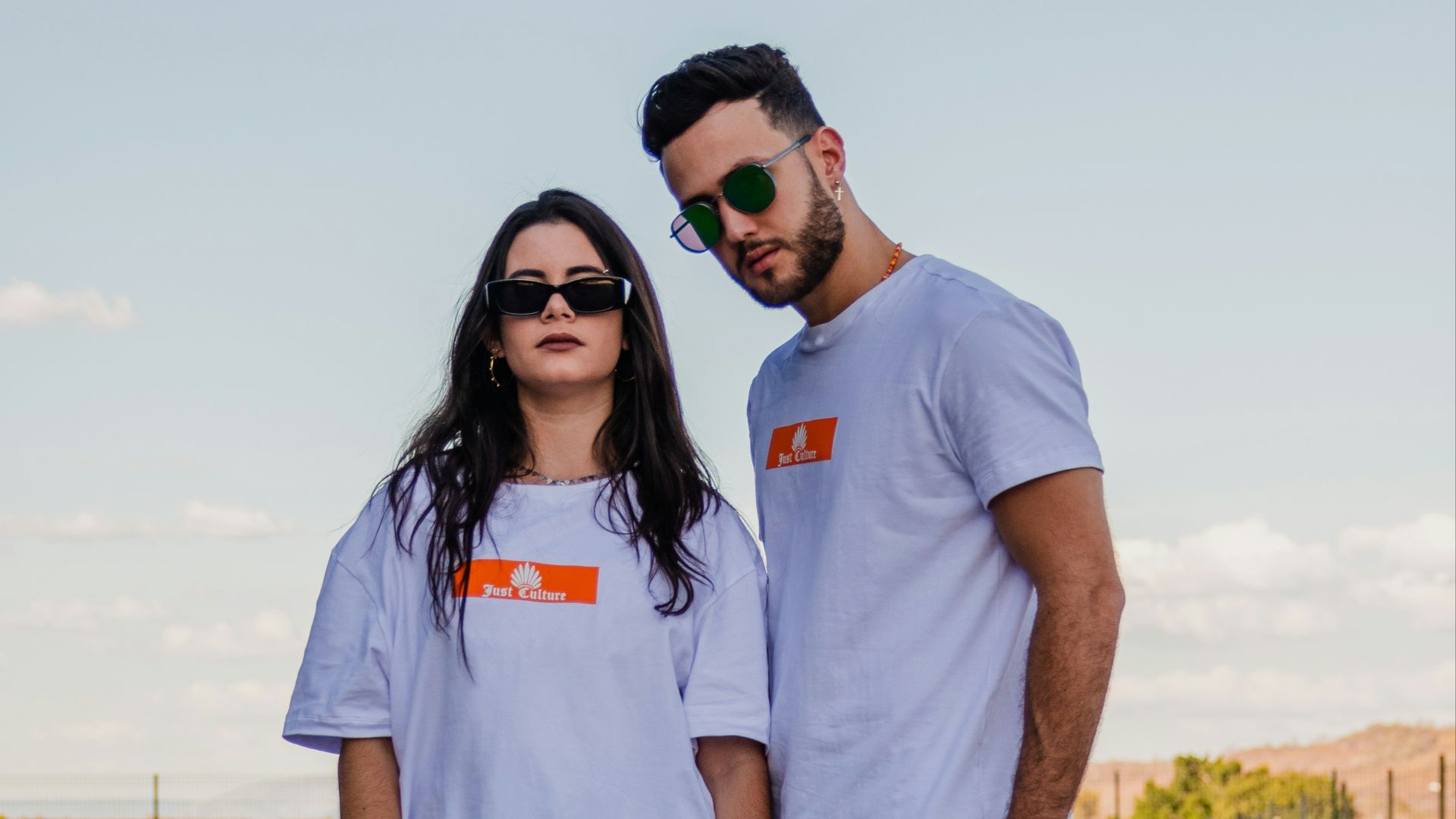 woman in white crew neck t-shirt and blue denim shorts standing on gray asphalt road