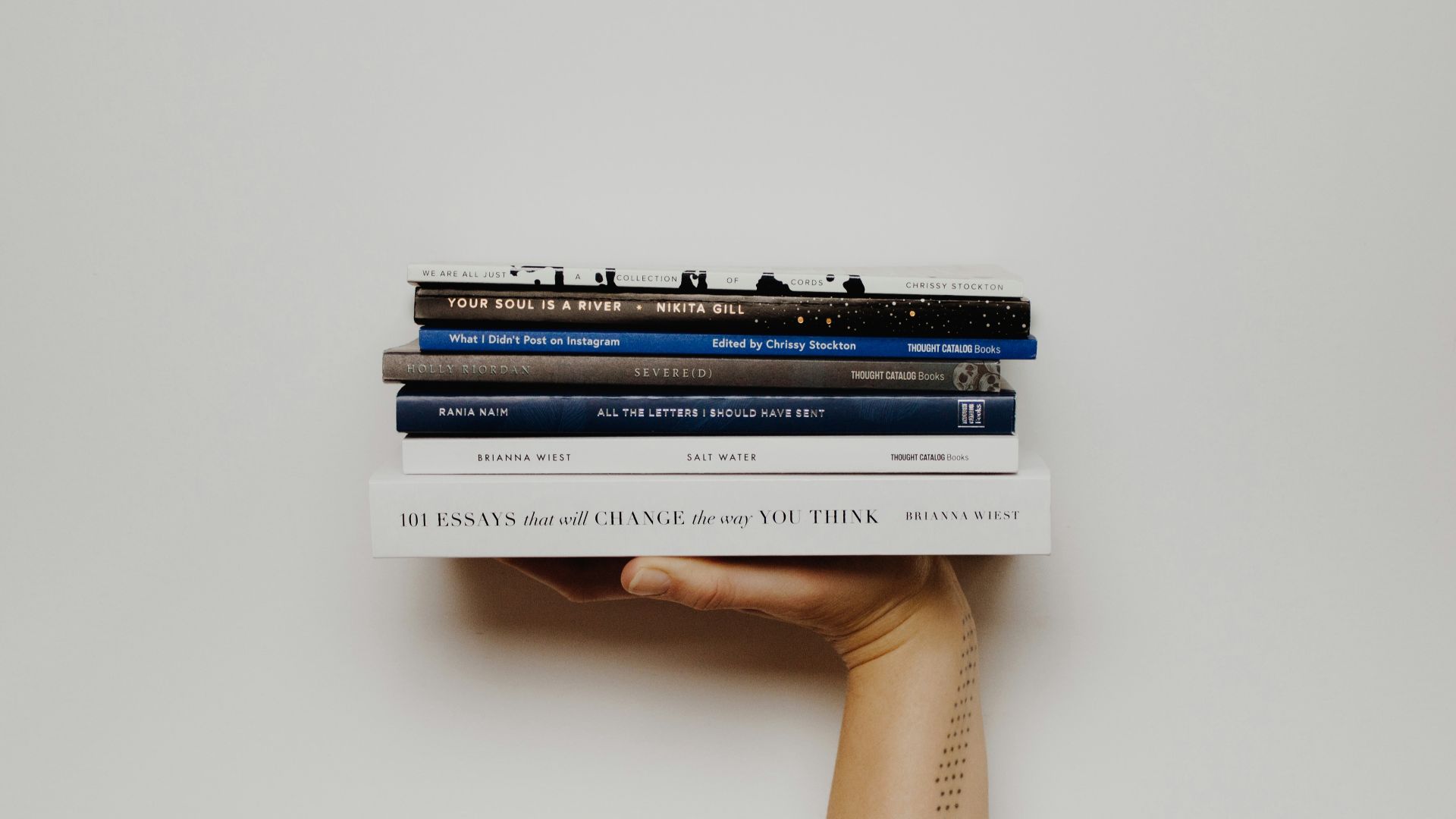 person holding pile of books