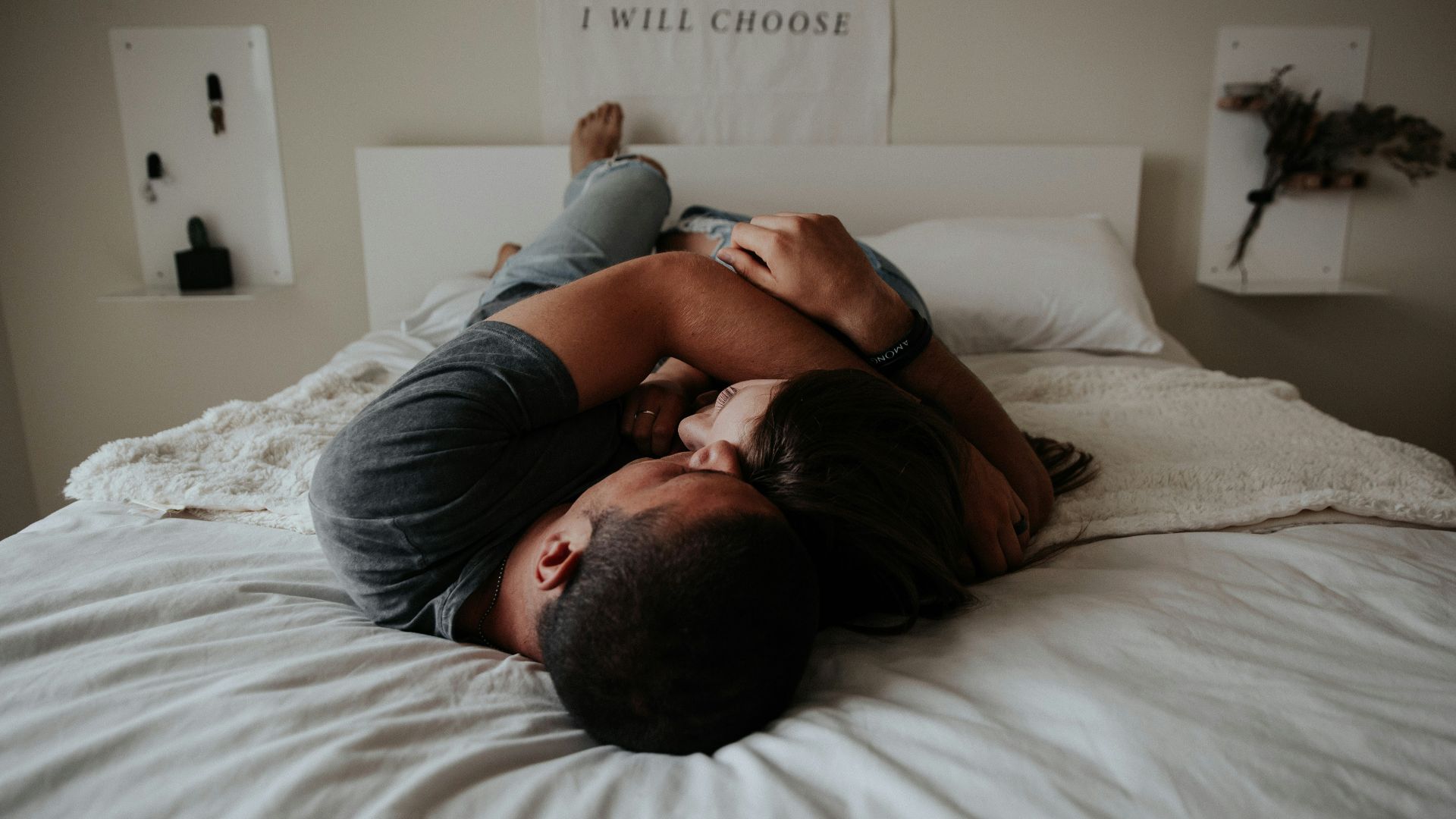 A man and woman cuddling together in bed.