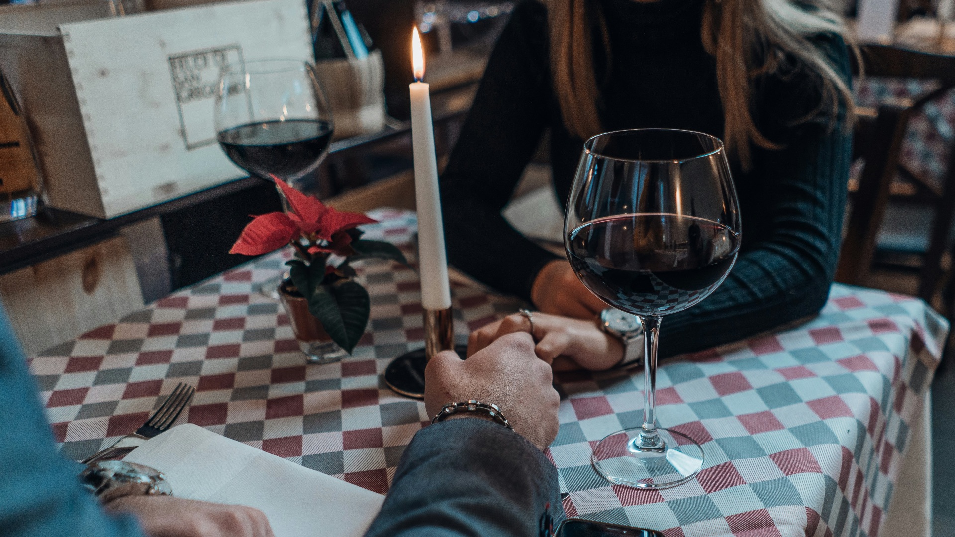 woman wearing black sweater holding hand with man wearing gray suit jacket