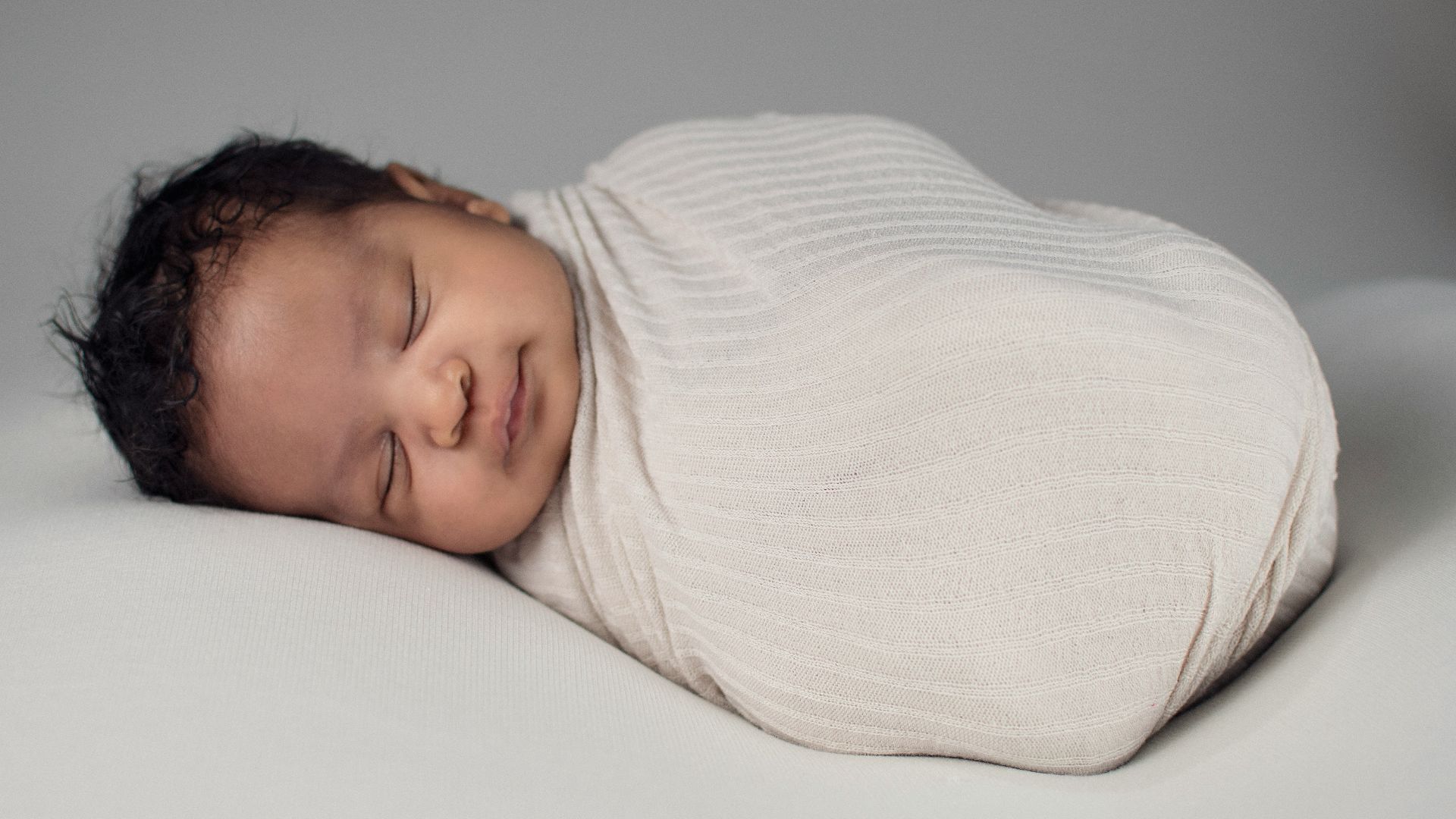 woman in white knit sweater lying on bed