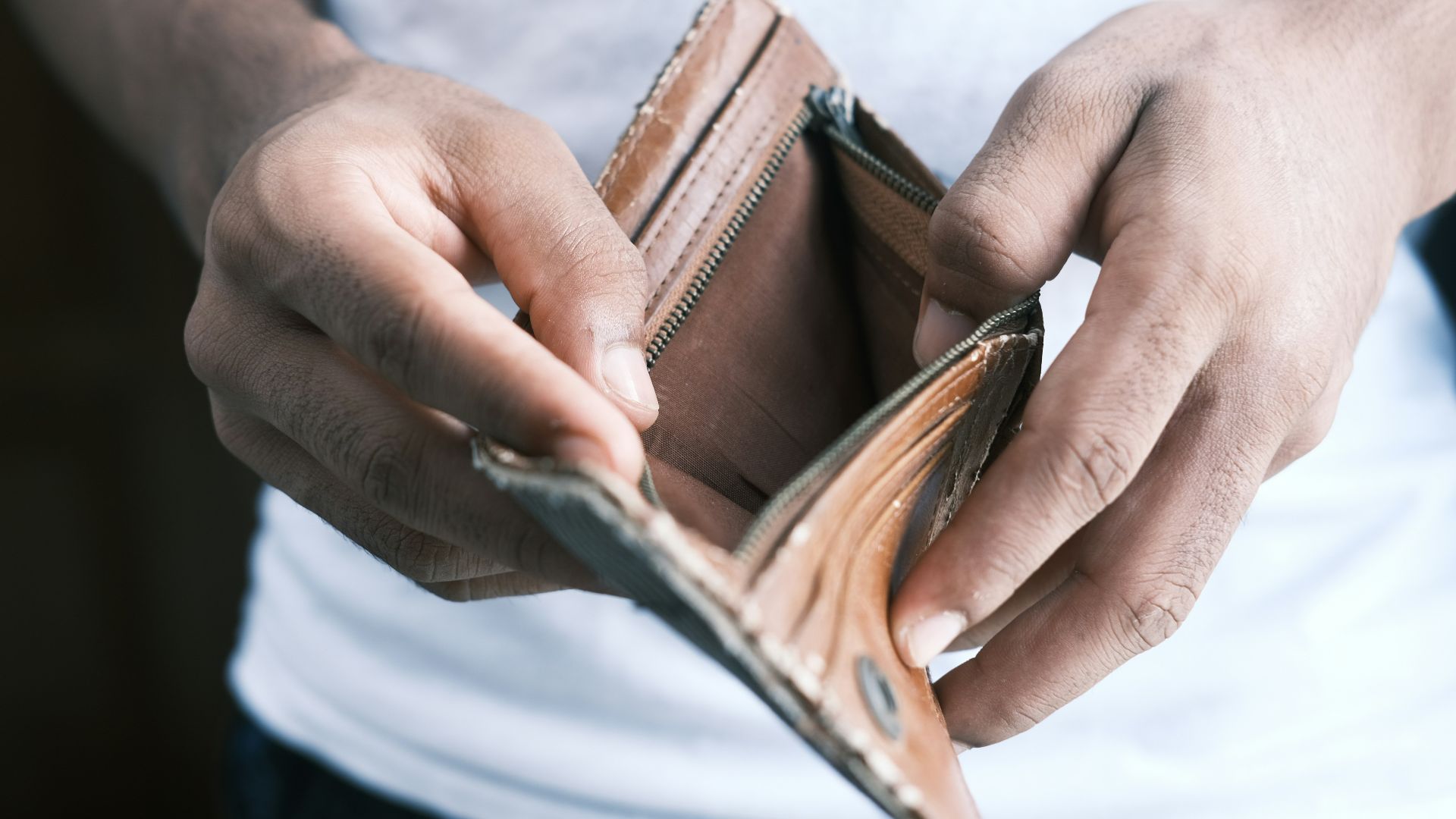person holding brown leather bifold wallet