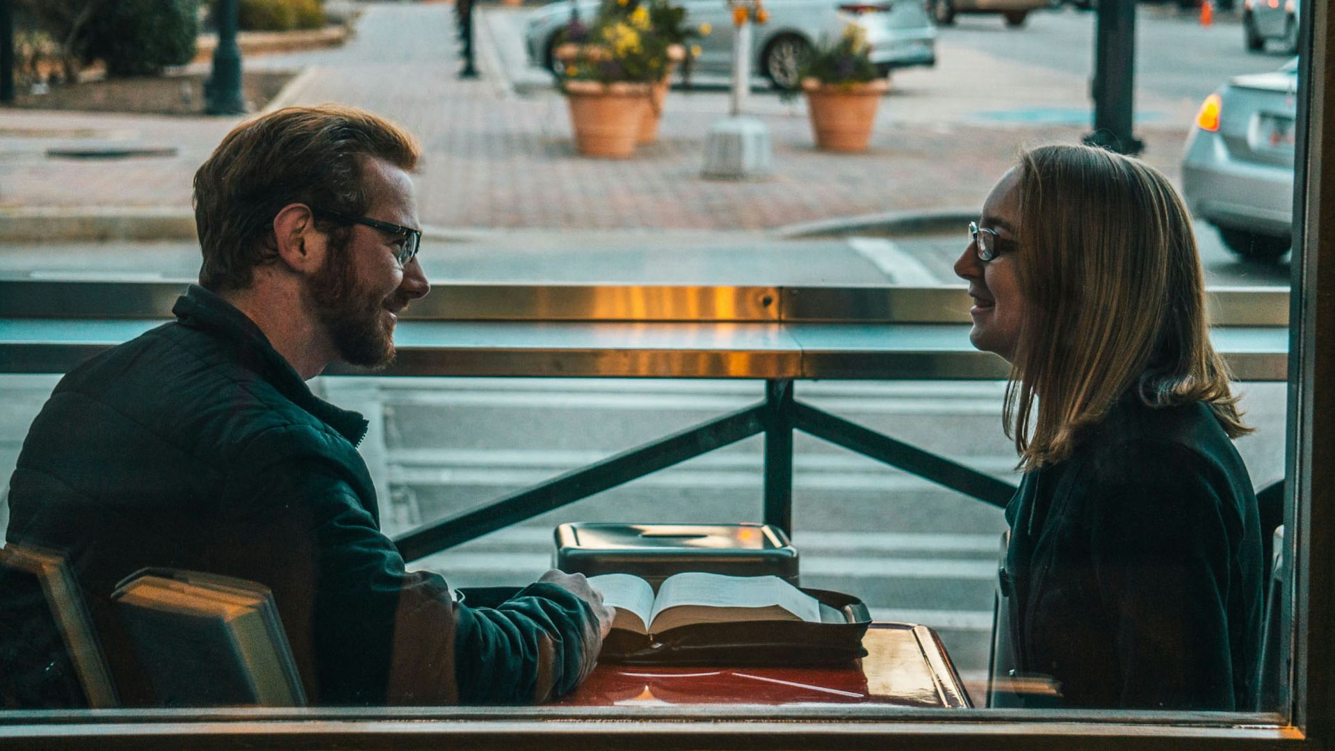 man and woman sitting while talking during daytime