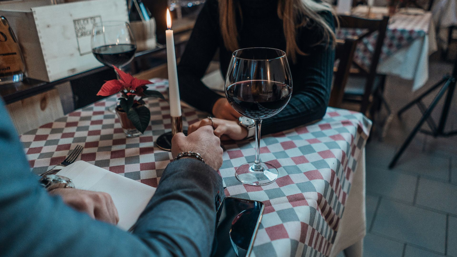 woman wearing black sweater holding hand with man wearing gray suit jacket