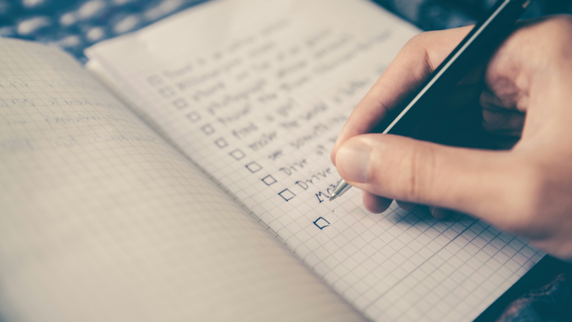 person writing bucket list on book