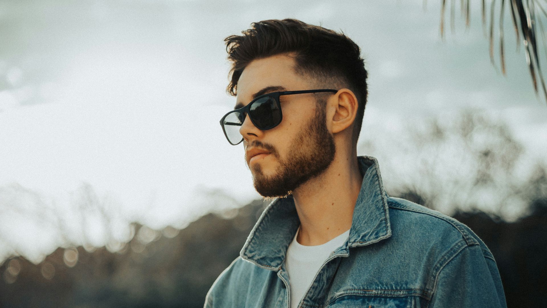 man in blue denim jacket wearing black sunglasses