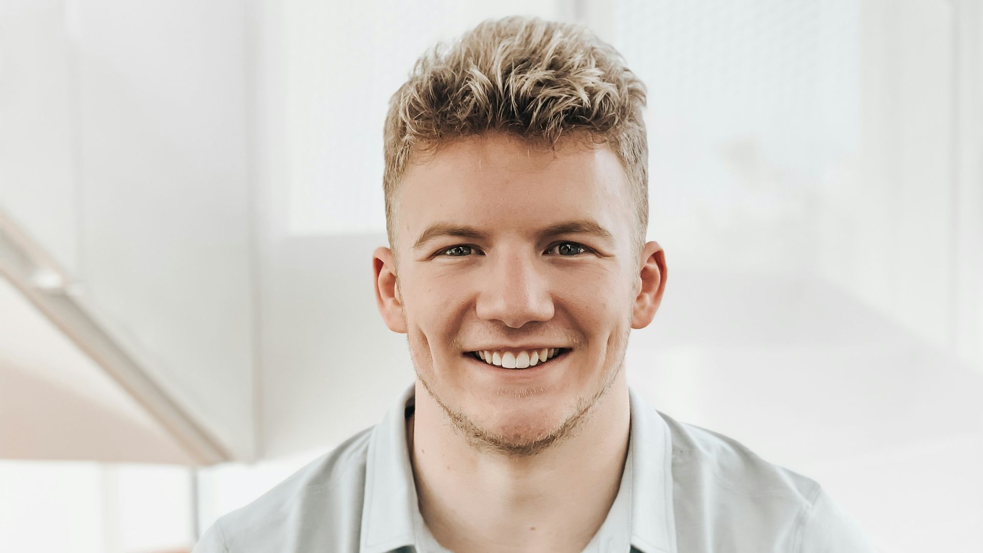 man in gray polo shirt smiling