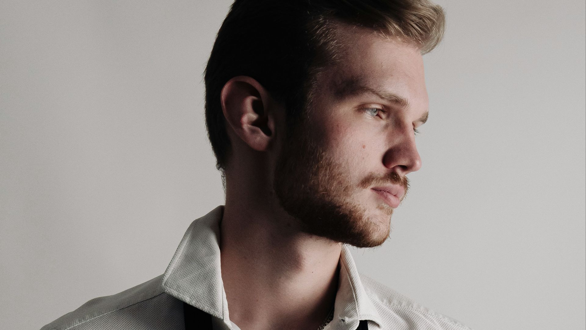 a man in a white shirt and black suspenders