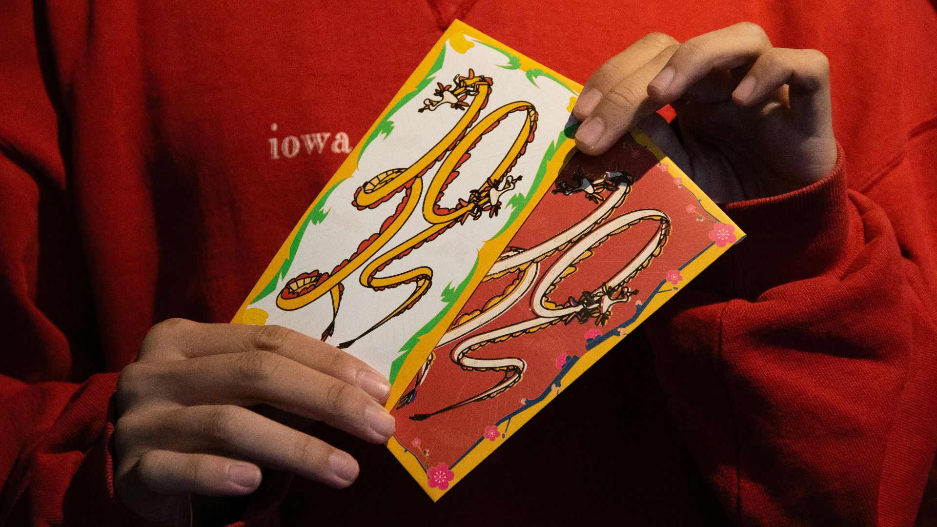 a person in a red shirt holding a card with a snake on it