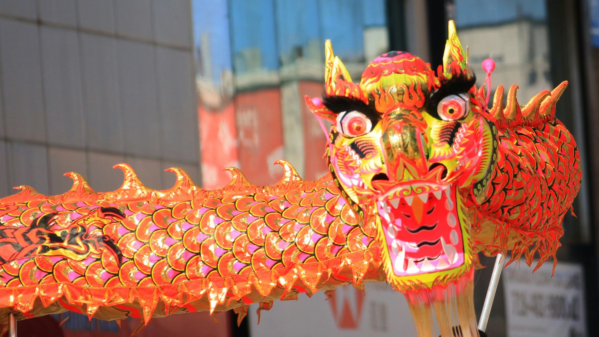 a woman in a red headdress holding a dragon lantern