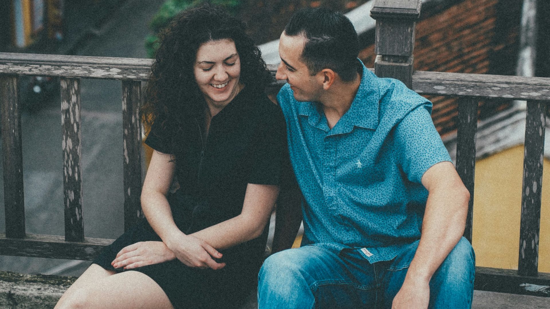 Couple sitting on a balcony overlooking old buildings