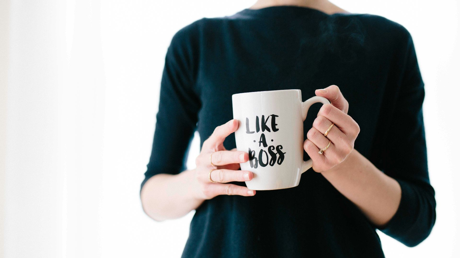 woman holding white mug while standing