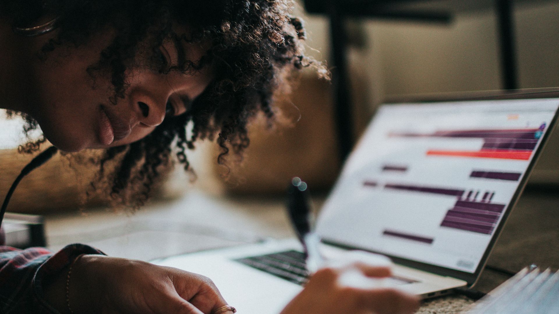 woman in black and white shirt writing on white paper