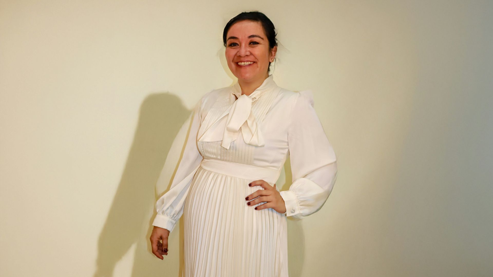Woman in elegant white pleated dress with train
