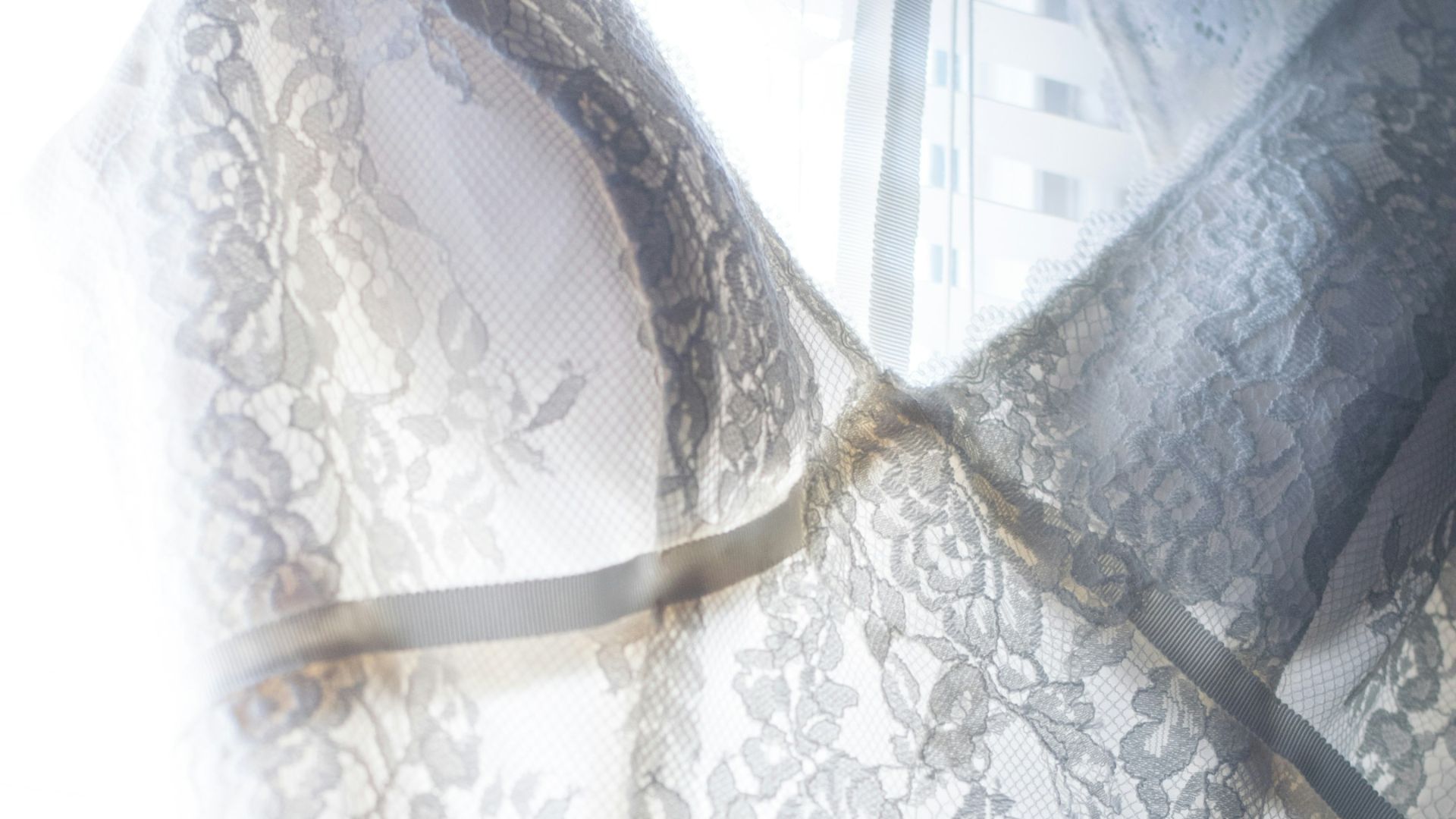 a dress hanging on a hanger in front of a window