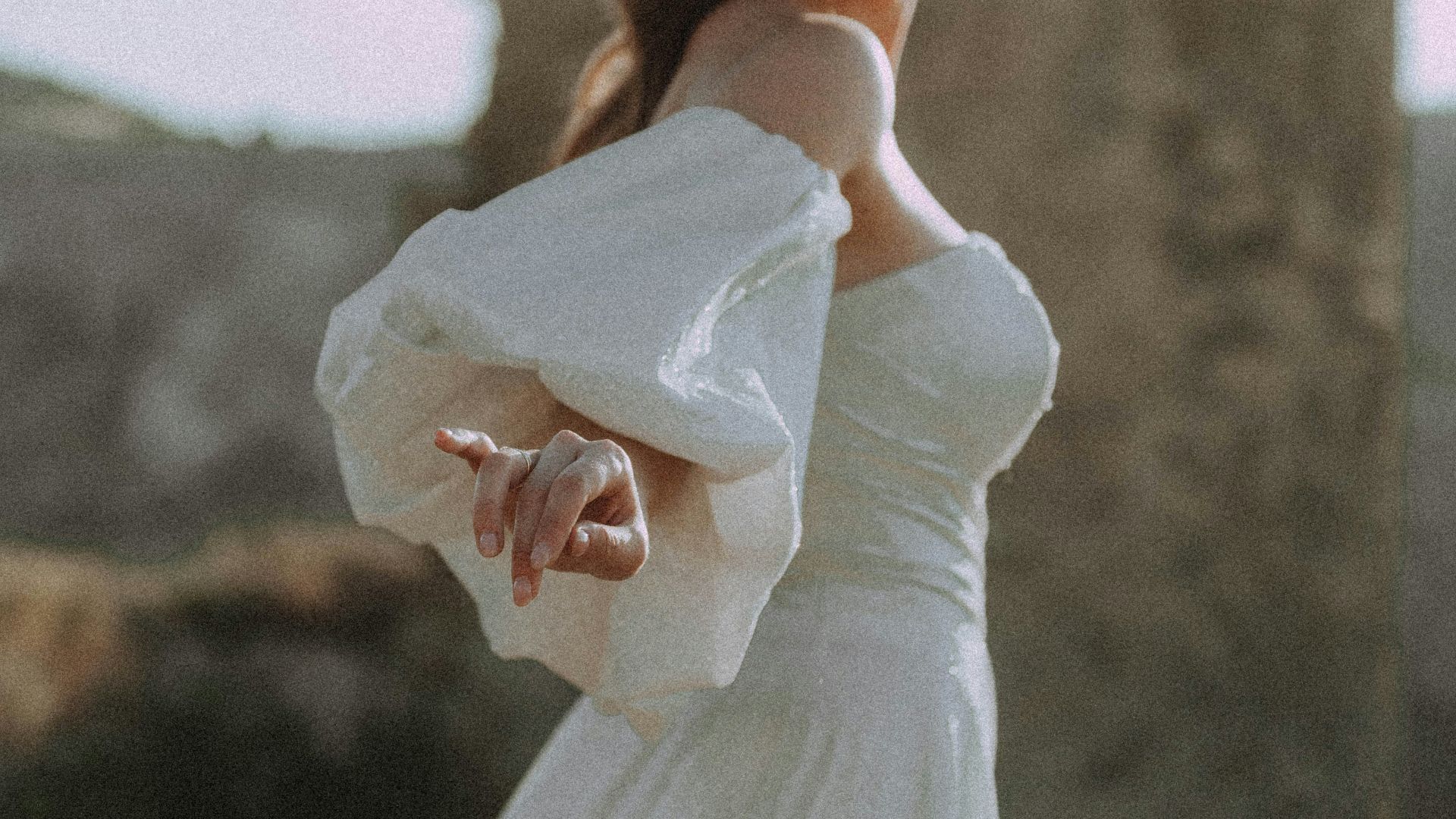 a woman in a white dress standing in a field